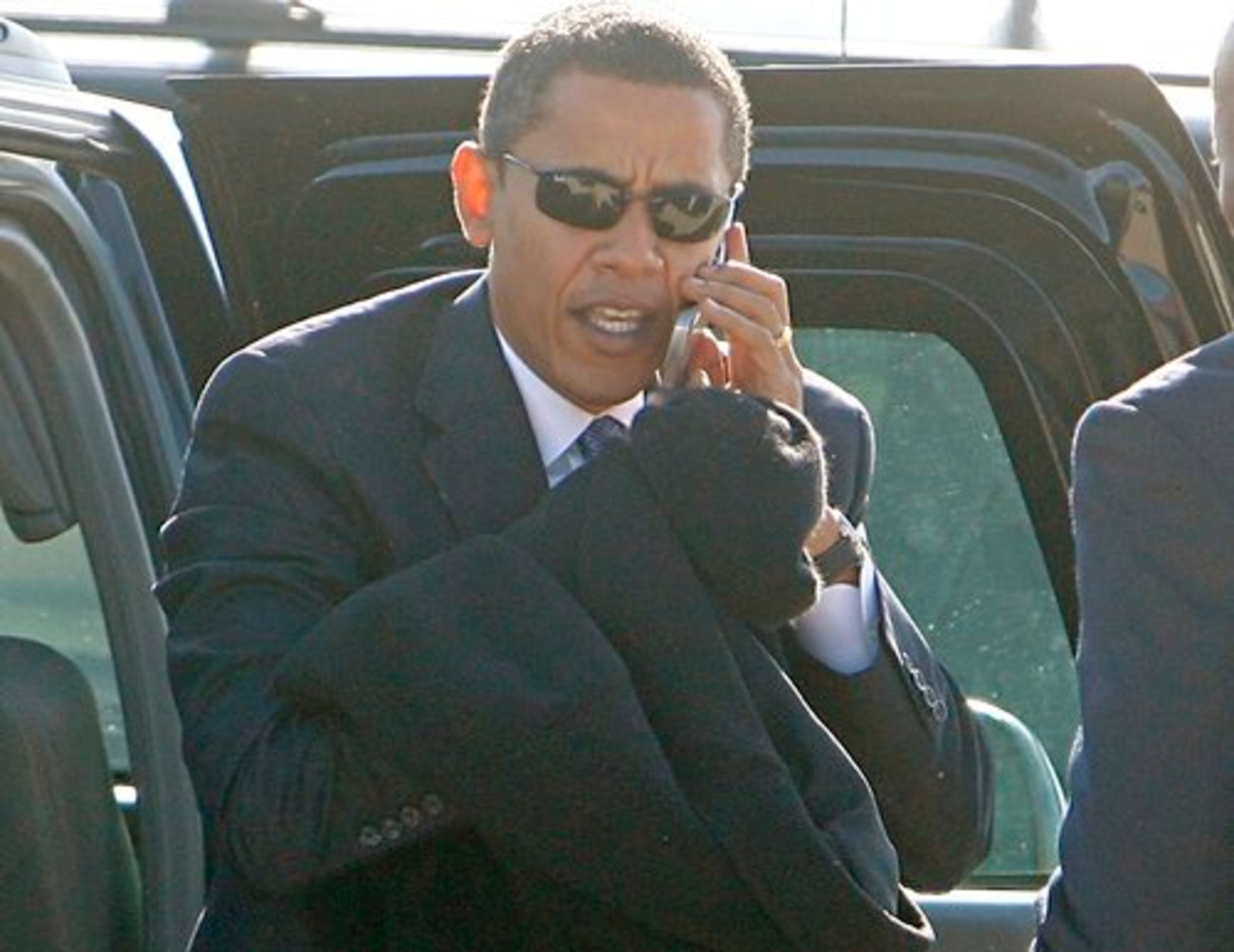 President-elect Obama talks on a cell phone as he steps out of his vehicle to board his plane at Chicago's O'Hare International Airport, en route to Washington D.C.