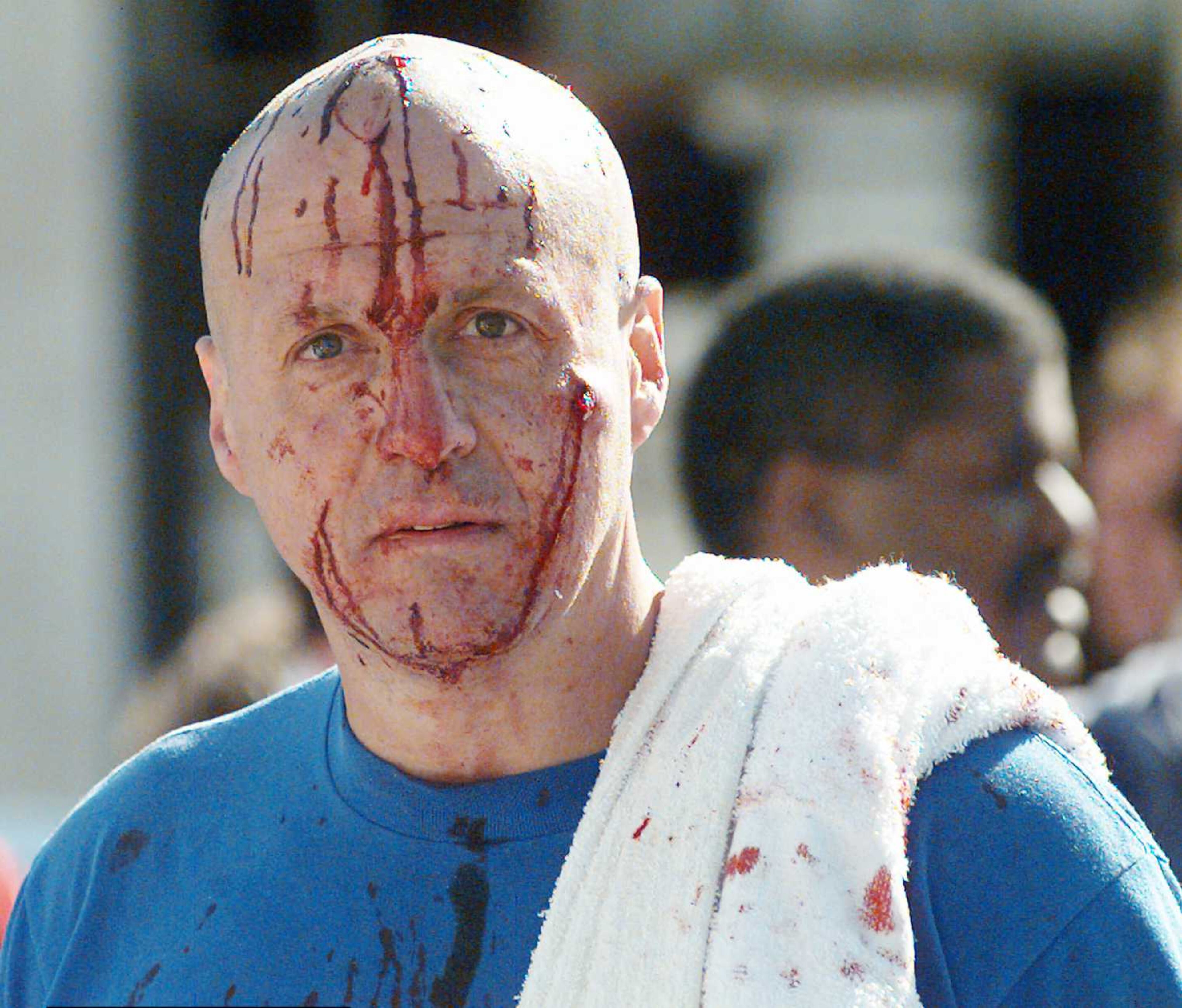 An unidentified man his face smeared with blood looks at the bomb damaged Alfred Murrah Federal Building Wednesday morning April 19 1995. (AP Photo/ David Longstreath)