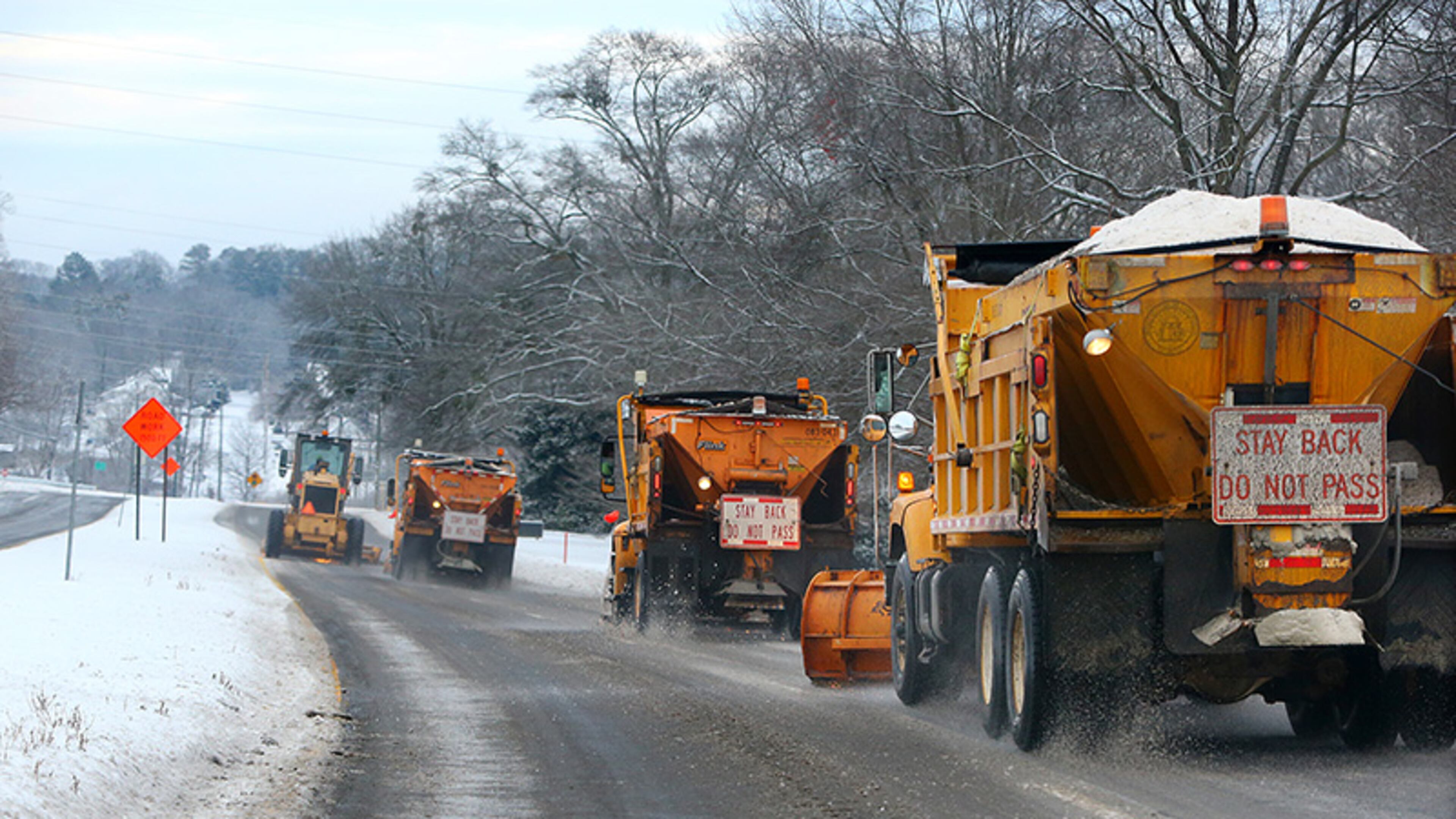 A squadron of GDOT snow plows follow behind a heavy construction plow clearing and dropping rock and salt on Jesse Jewell Parkway in Gainesville after yet another round of snow and ice on Thursday.