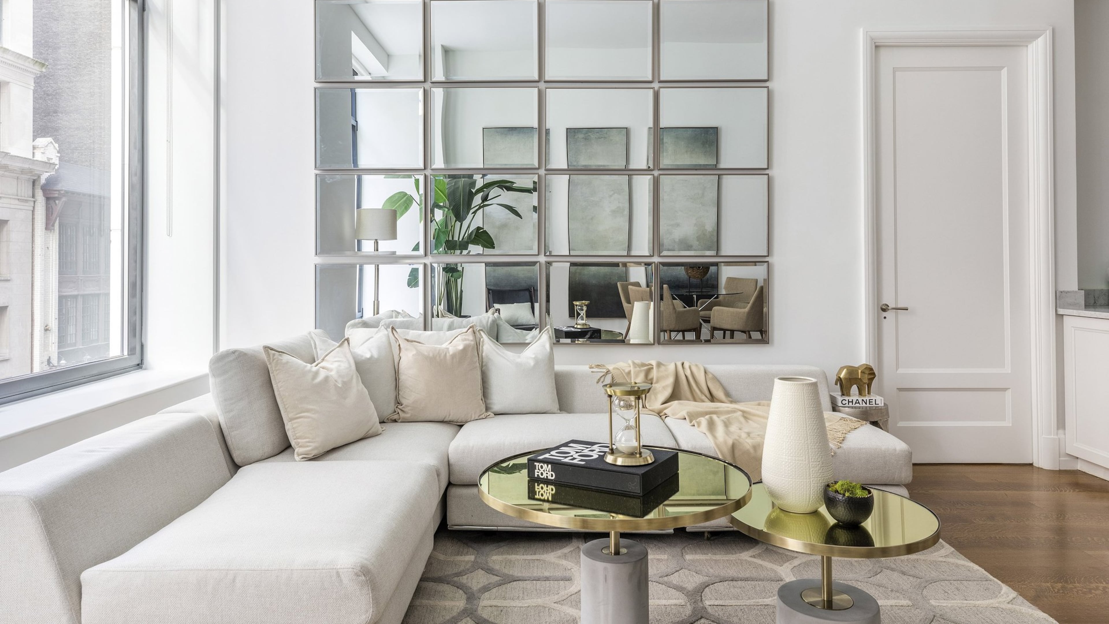 A wall of mirrors helps a small living room feel open and spacious. (Design Recipes)