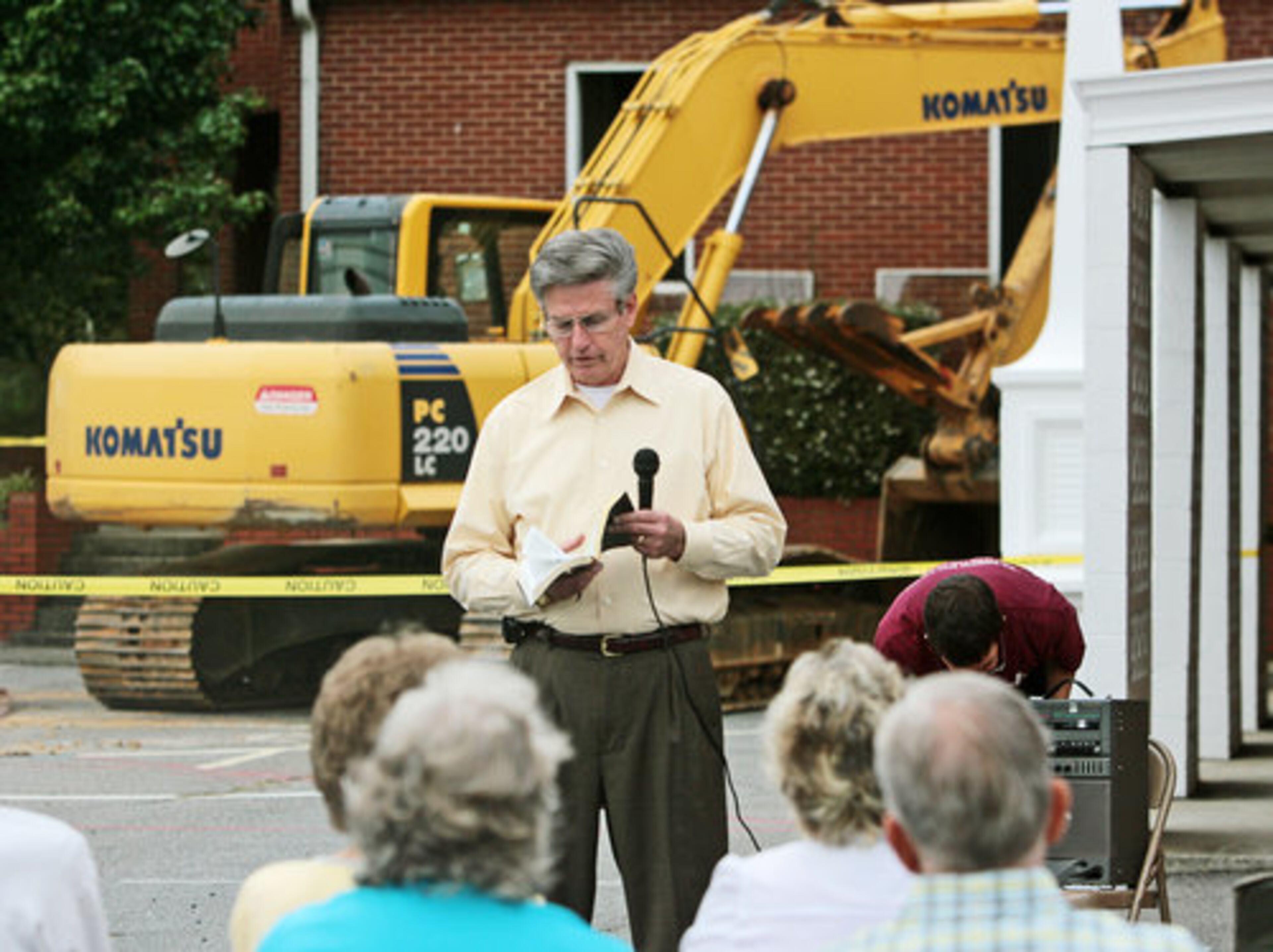 Pastor Ted McClung leads the congregation in a prayer service before the demolition begins.