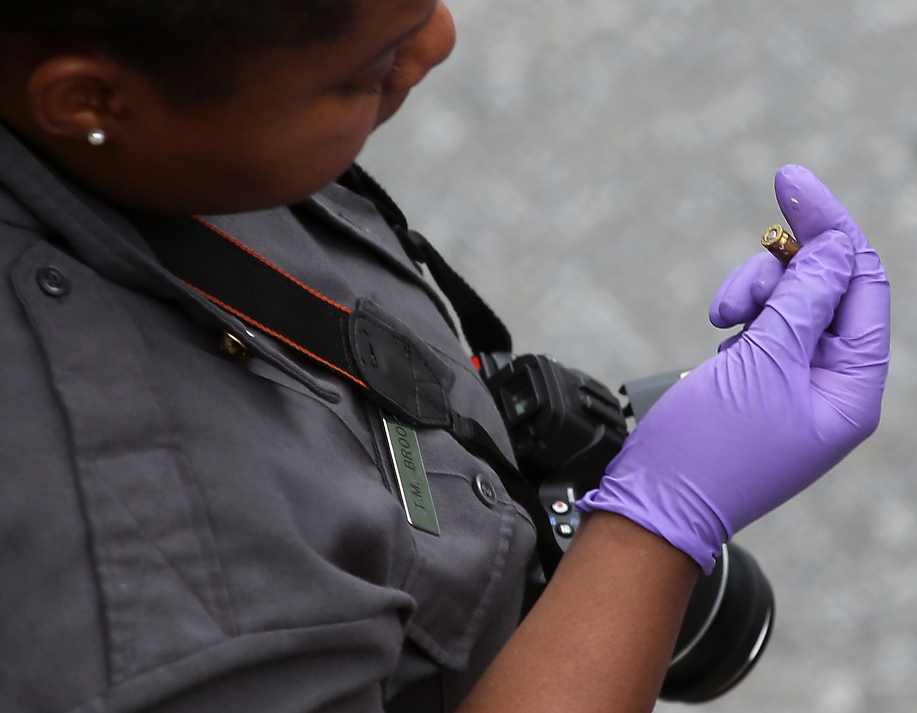 DeKalb County Police crime scene investigator looks at a spent bullet casing found near the spot a man was found shot in a black Maybach on I-20 Thursday evening April 11, 2013. BEN GRAY / BGRAY@AJC.COM