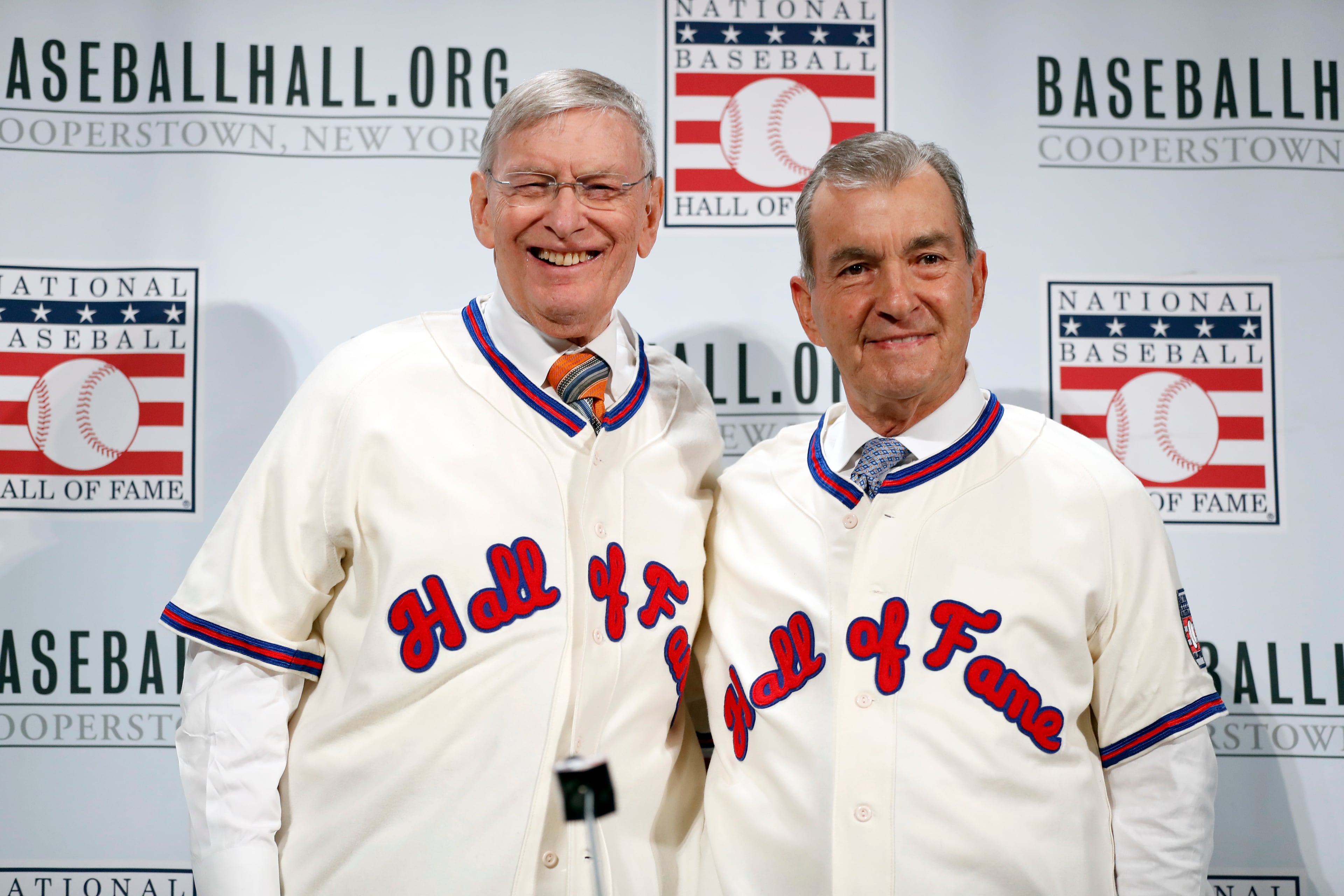 In this Dec. 5, 2016, file photo, former commissioner Bud Selig, left, and Atlanta Braves president John Schuerholz pose with their Hall of Fame jerseys on during a media availability at Major League Baseball's winter meetings, in Oxon Hill, Md. Selig, Schuerholz, Tim Raines, Jeff Bagwell and Ivan Rodriguez each carved his own niche in major league baseball, and on Sunday they will receive the game's ultimate reward _ induction into the Hall of Fame.