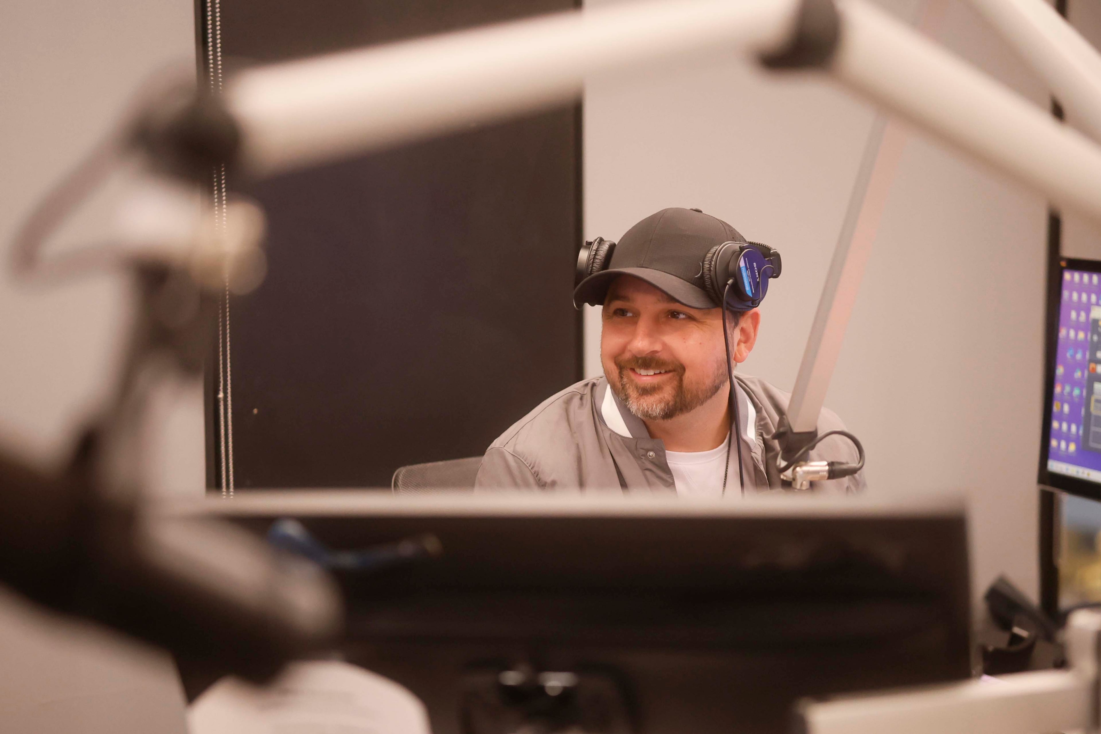 Bret Mega smiles while speaking to listeners during “The Bret Mega Morning Show” on Star 94. (Miguel Martinez/AJC)