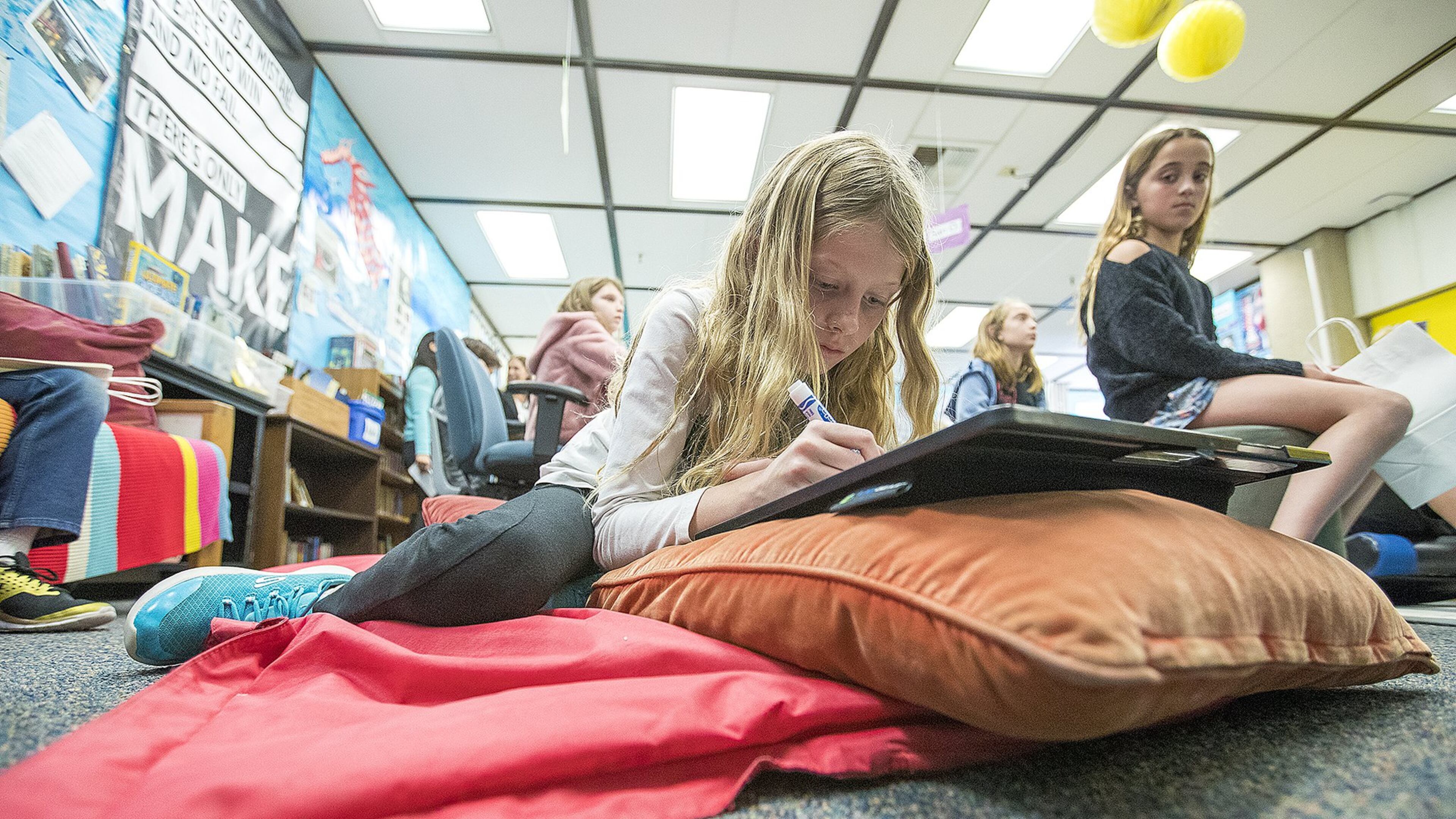 Amanda Garrett, 9, works on a project while lying on a mat during a fourth-grade class at Anderson Elementary School in Newport Beach, California. Contributed by Scott Smeltzer/Los Angeles Times/TNS