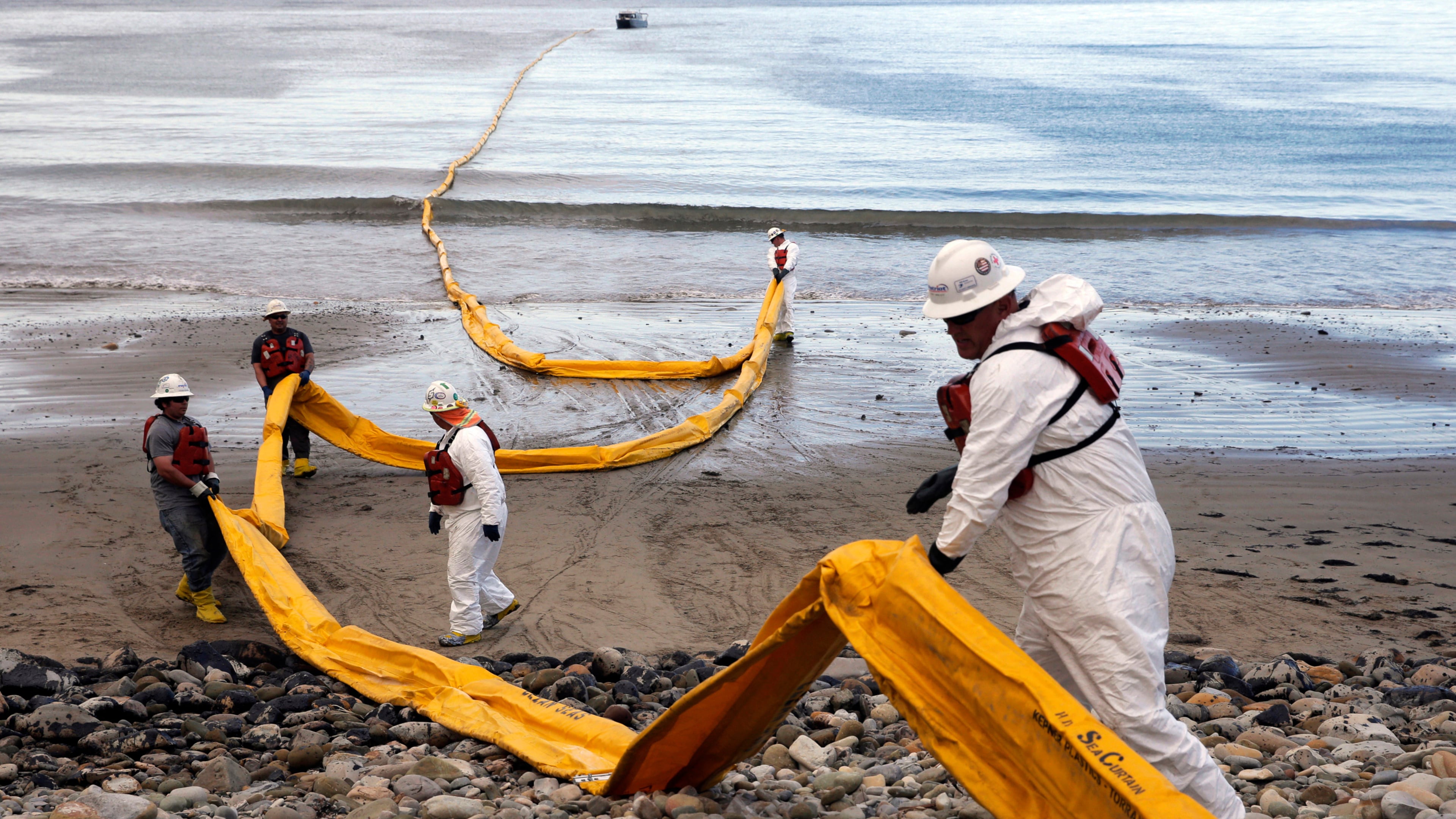 FILE - Workers prepare an oil containment boom at Refugio State Beach, north of Goleta, Calif., on May 21, 2015, two days after an oil pipeline ruptured, polluting beaches and killing hundreds of birds and marine mammals. (AP Photo/Jae C. Hong, File)