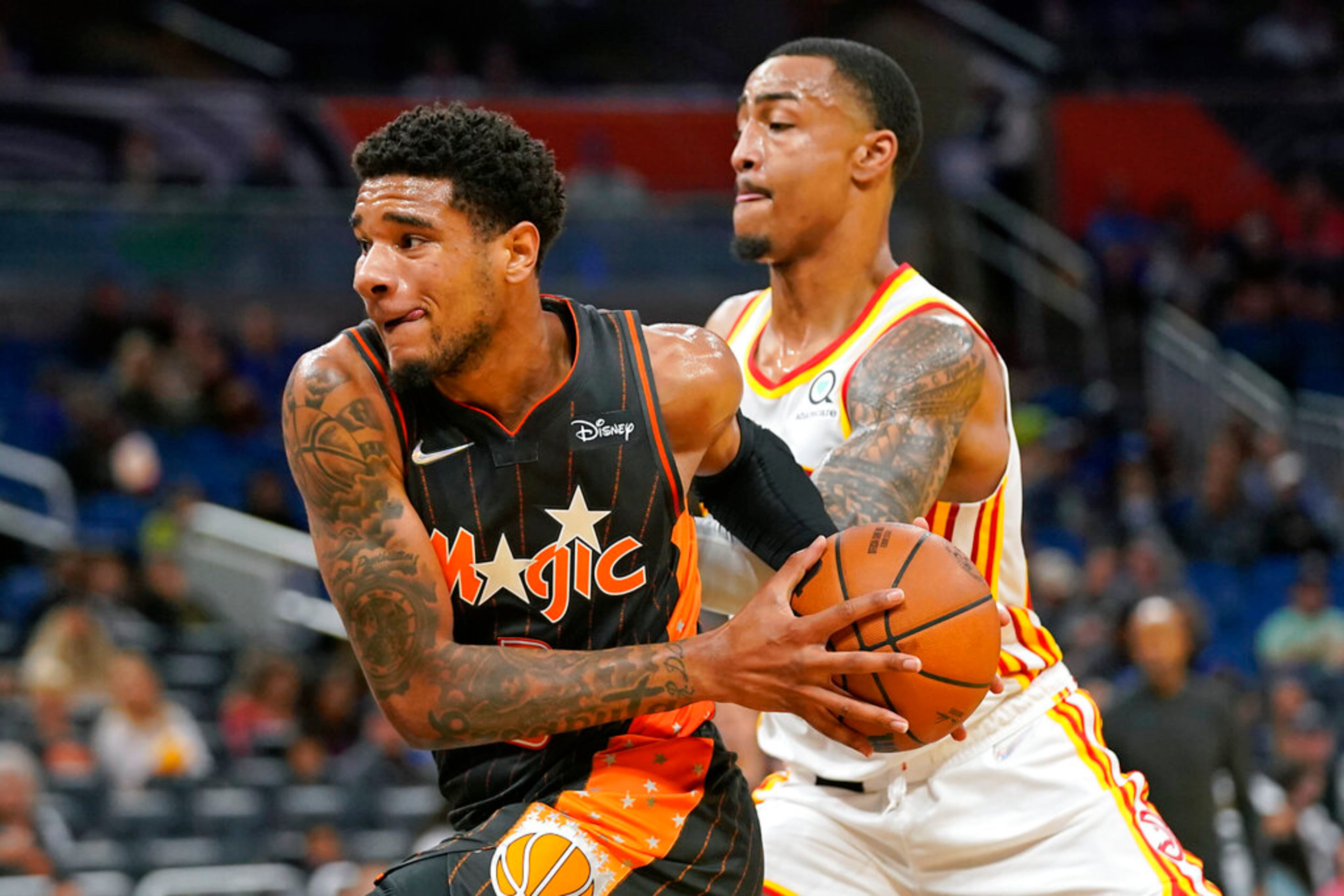 Orlando Magic forward Chuma Okeke, left, drives around Atlanta Hawks forward John Collins during the second half of an NBA basketball game, Wednesday, Dec. 15, 2021, in Orlando, Fla. (AP Photo/John Raoux)