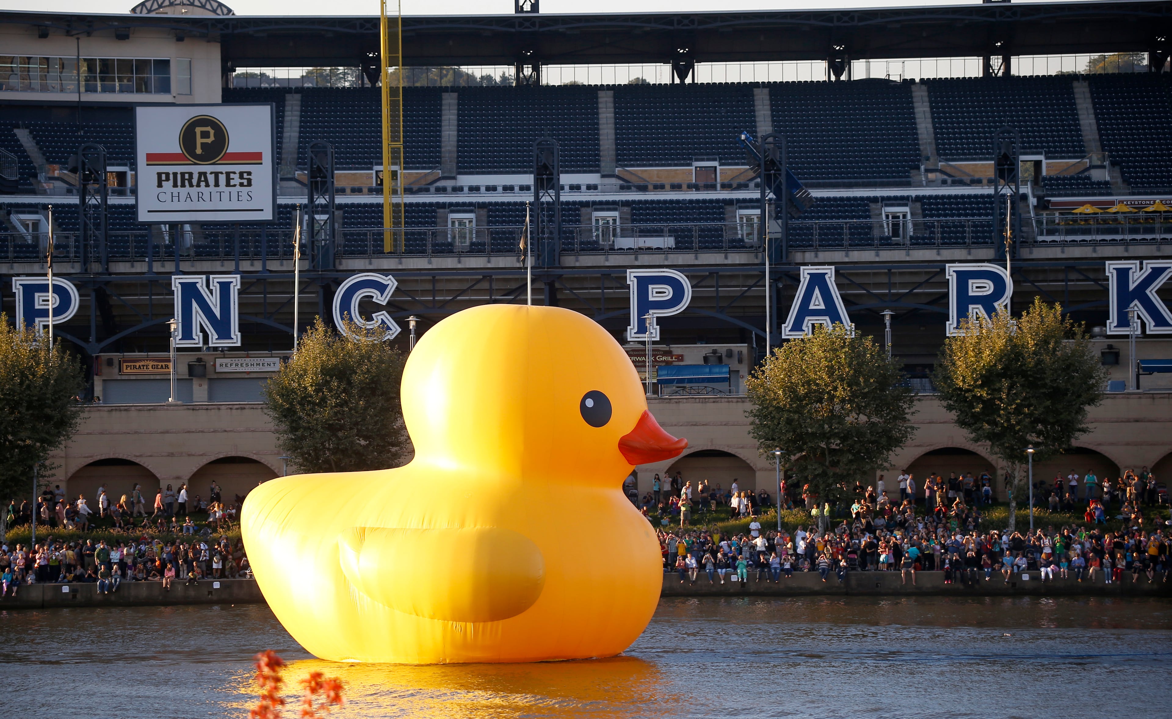 Thousands of people line both sides of the Allegheny River as a version of Dutch artist Florentijn Hofman giant "Rubber Duckie" is towed past PNC Park for its debut in Pittsburgh on Friday, Sept. 27, 2013. Pittsburgh's duck is the first "Made-in-the-USA" version of the Dutch artists creation. The ducks arrival kicks off the month-long Pittsburgh International Festival of Firsts, which features theater, dance, music and visual arts from around the world. After the opening night the duck will be moored downtown until Oct. 20, 2013. (AP Photo/Keith Srakocic)