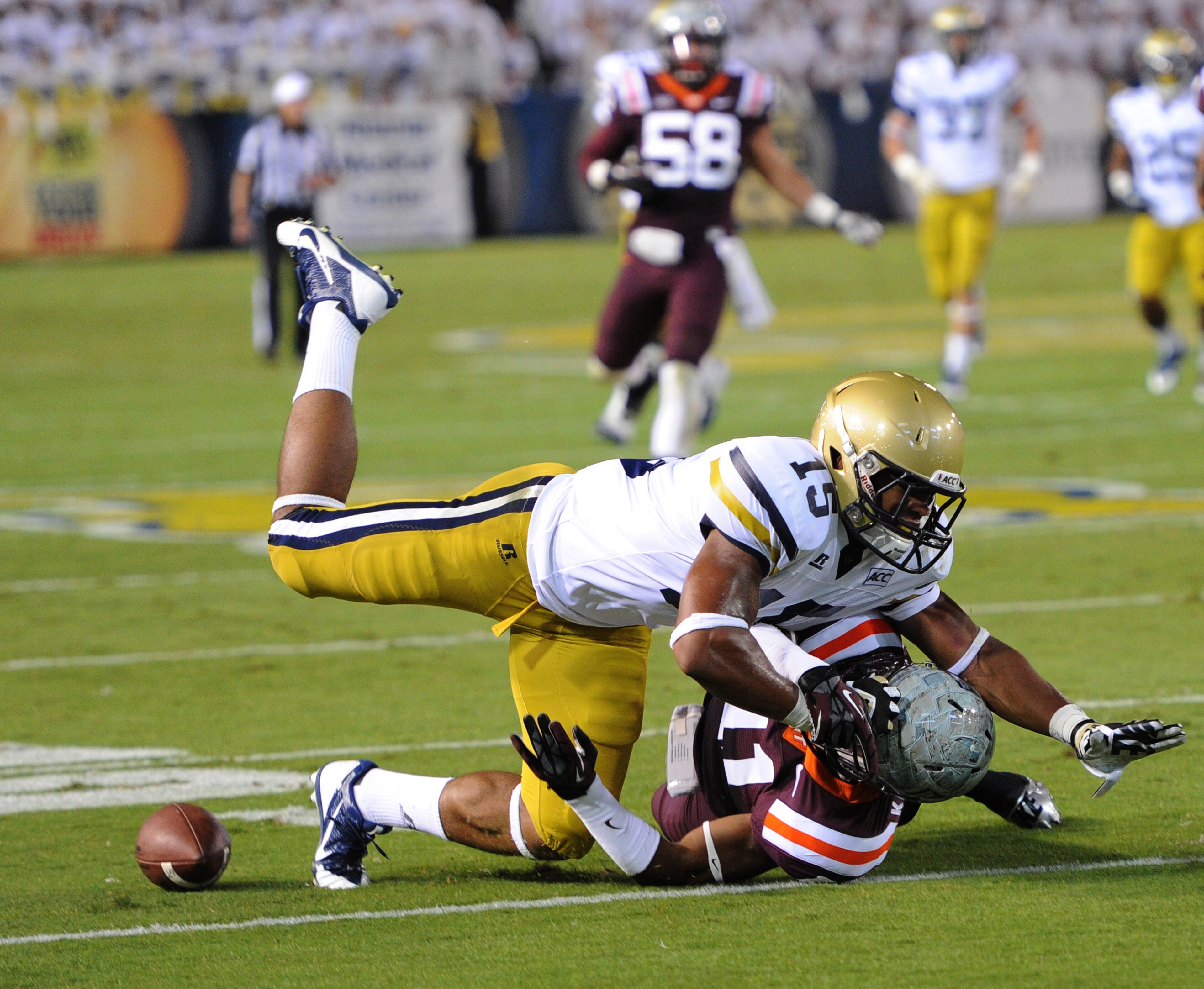 Georgia Tech's DeAndre Smelter (15) is hit by Virginia Tech's Kendall Fuller (11) as he dives for the football in the first quarter during the Georgia Tech vs Virginia Tech game on Thursday, September 26, 2013.