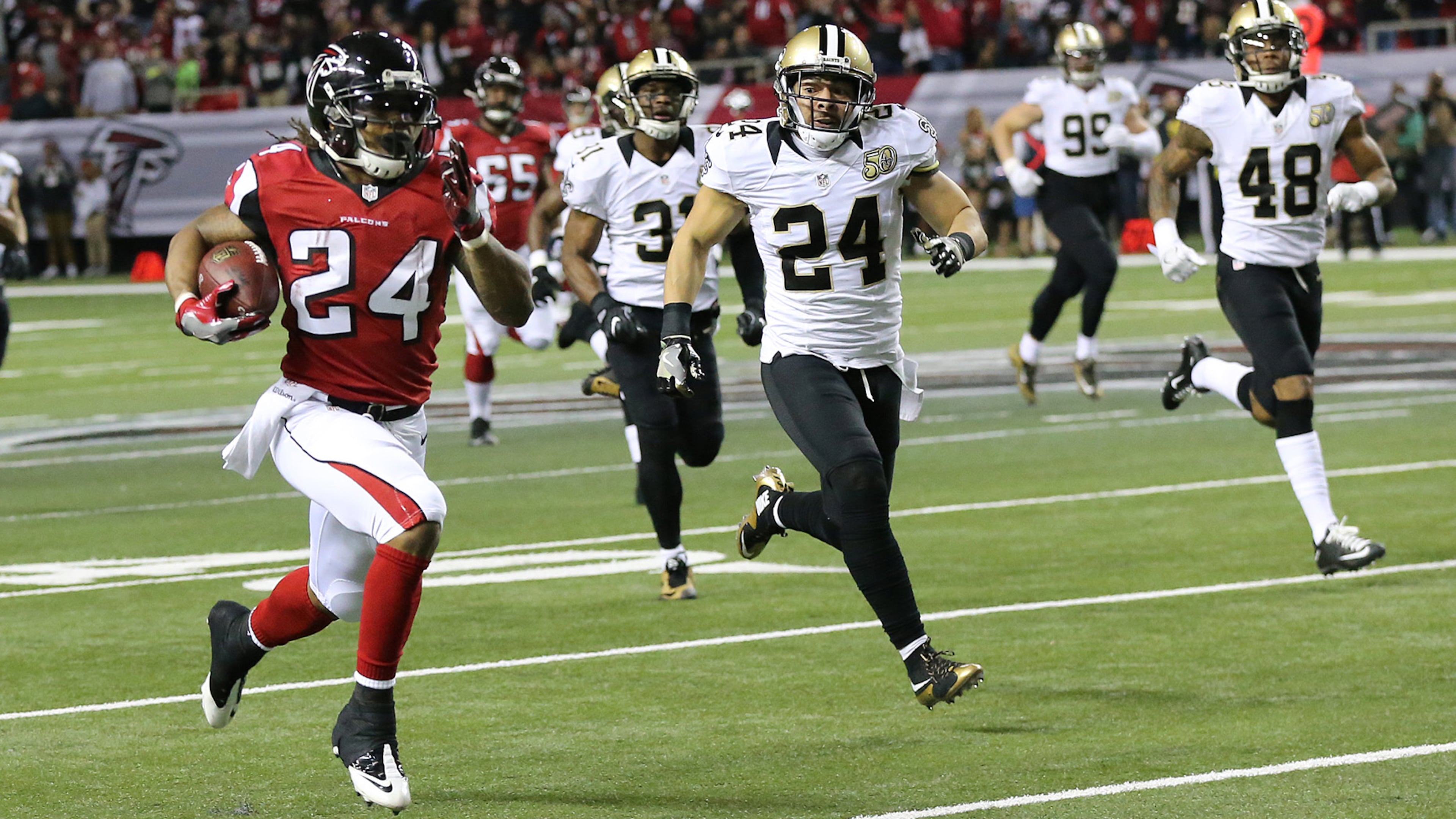 Falcons running back Devonta Freeman breaks away from Saints defenders for a 75-yard touchdown run to take a 14-3 lead during the first quarter Sunday, Jan. 1, 2017, at the Georgia Dome in Atlanta.