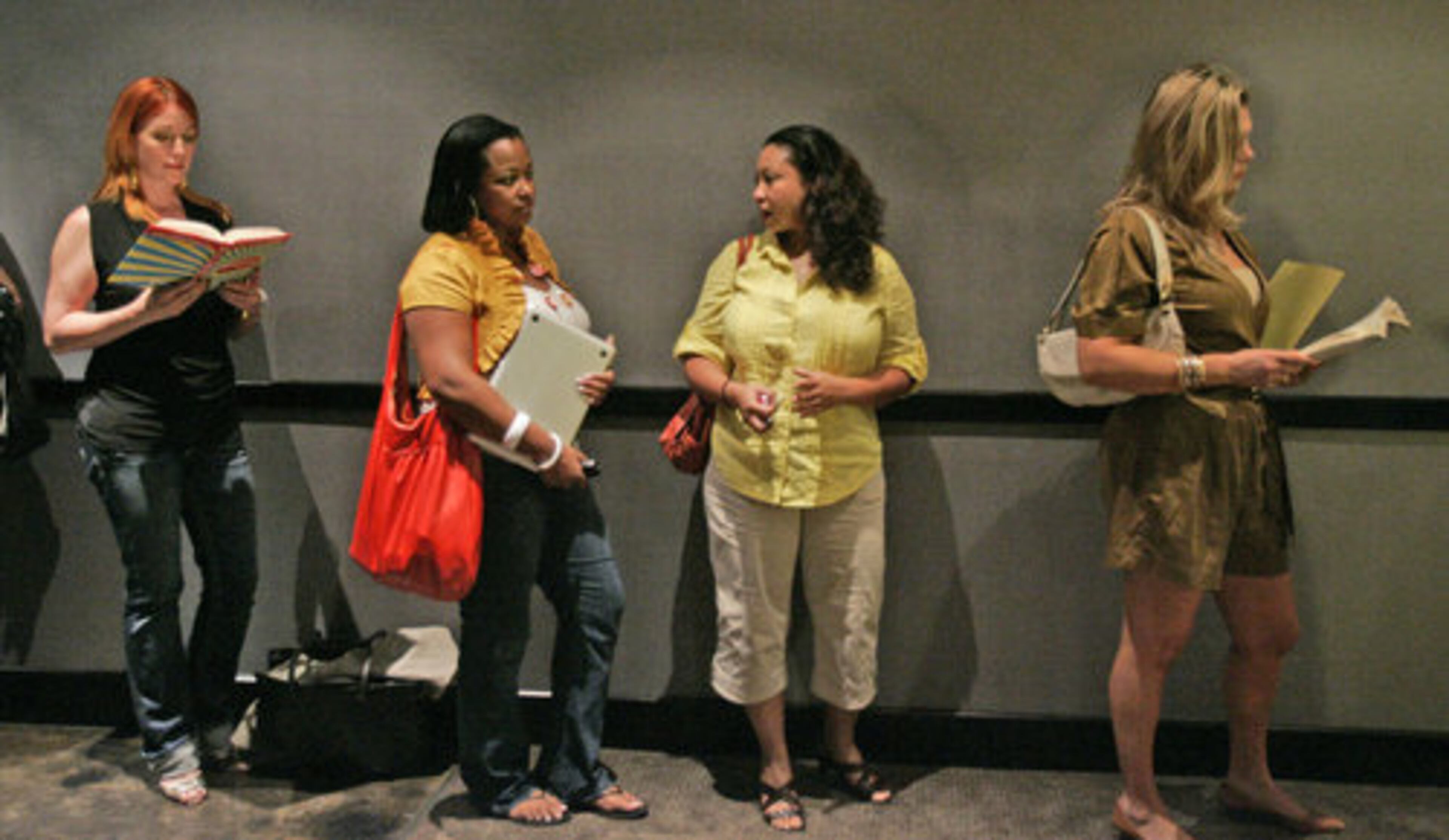 Left to right, Stephanie Nimmer, from Atlanta, Kourtenay James, from Atlanta, Kimleah Allen, from Atlanta, and Emily Womac, from Knoxville, find different ways to pass the time as they wait in line.