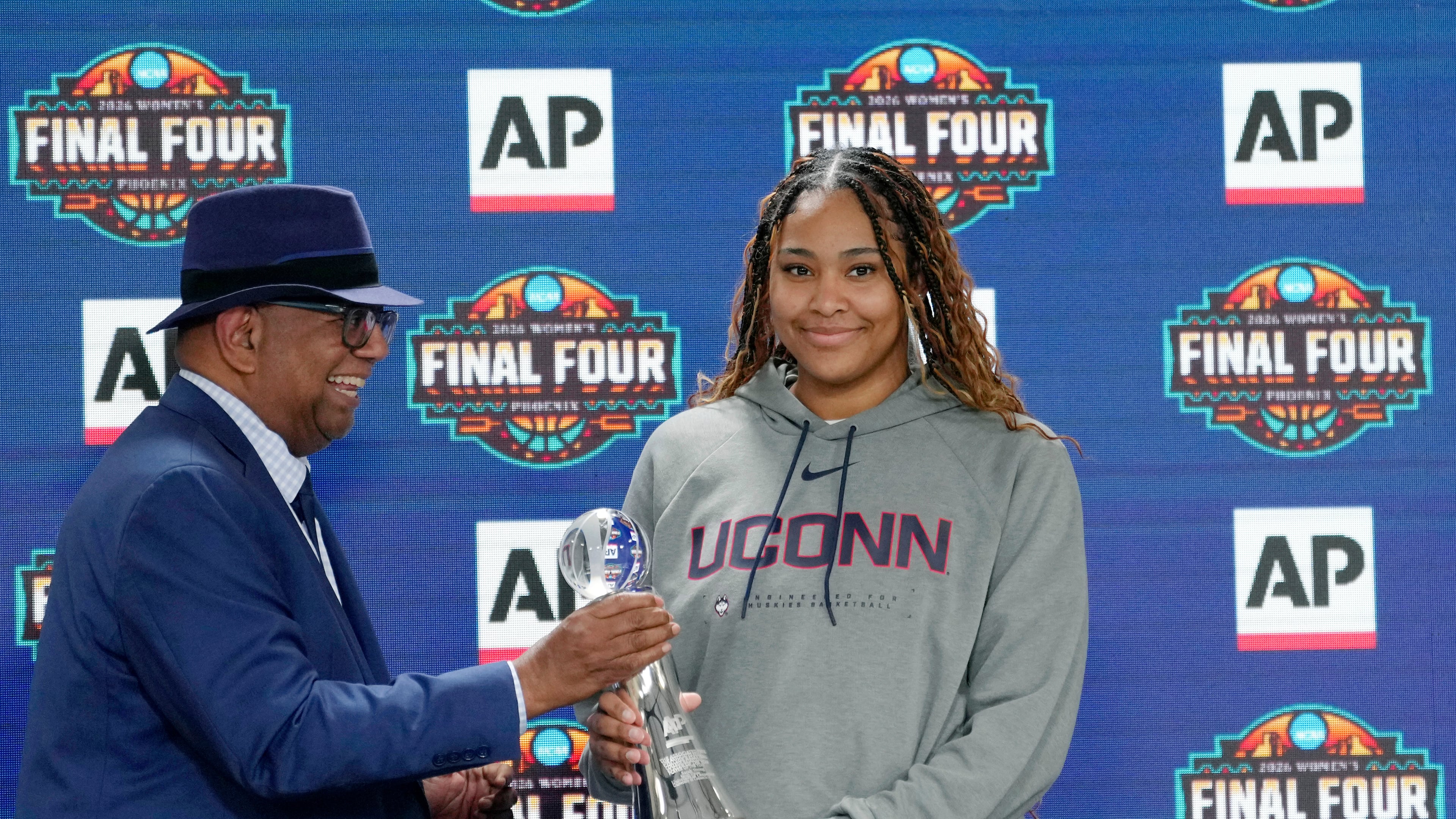 Associated Press deputy global sports editor Oscar Dixon, left, presents UConn's Sarah Strong with the 2026 AP Women's Player of the Year award during a news conference at the Women's Final Four of the NCAA college basketball tournament, Thursday, April 2, 2026, in Phoenix. (AP Photo/Ross D. Franklin)