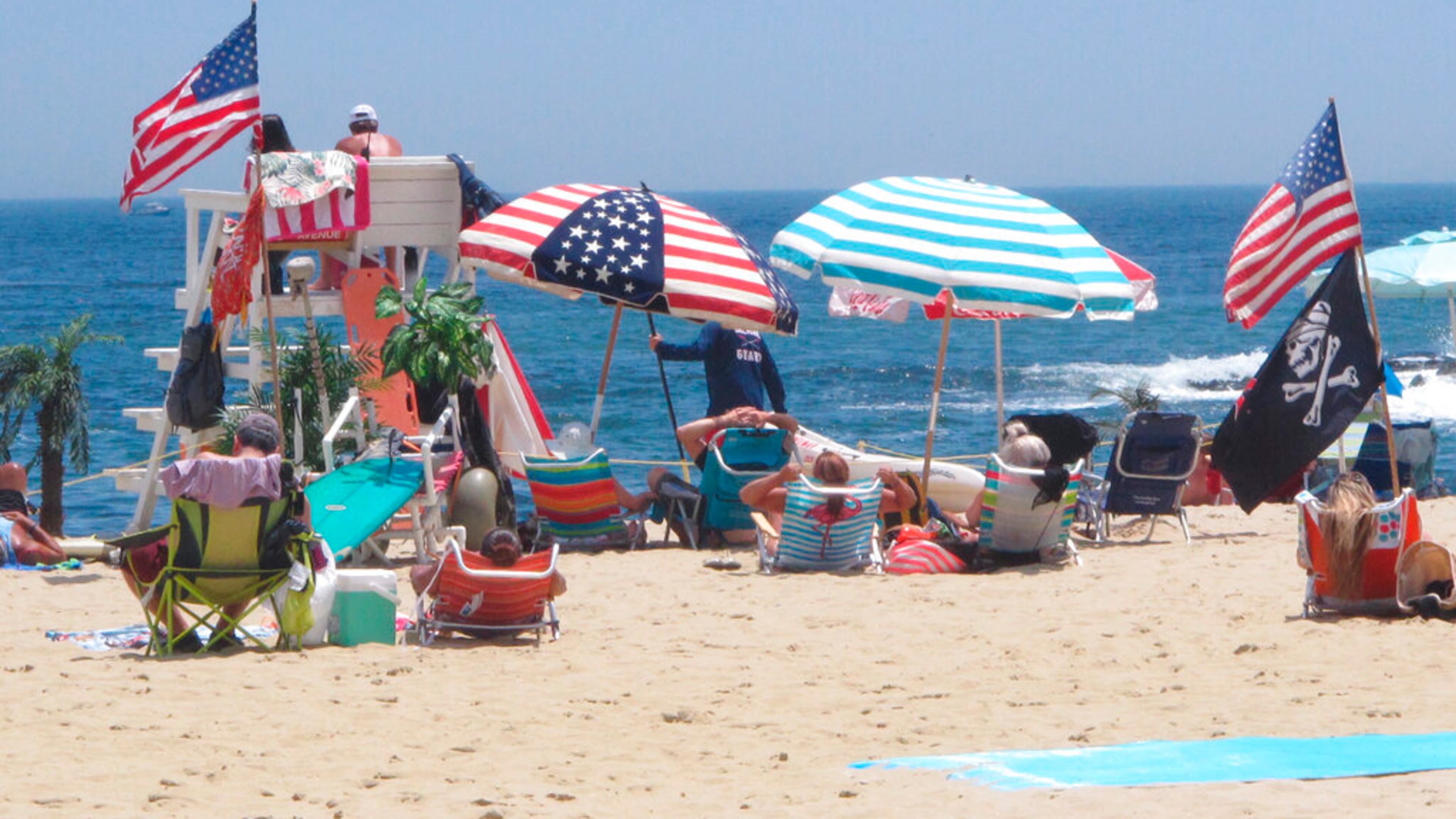 Flags line the beach in Belmar, N.J., on June 28, 2020. With large crowds expected at the Jersey Shore for the July Fourth weekend, some are worried that a failure to heed mask-wearing and social distancing protocols could accelerate the spread of the coronavirus. (AP Photo/Wayne Parry)