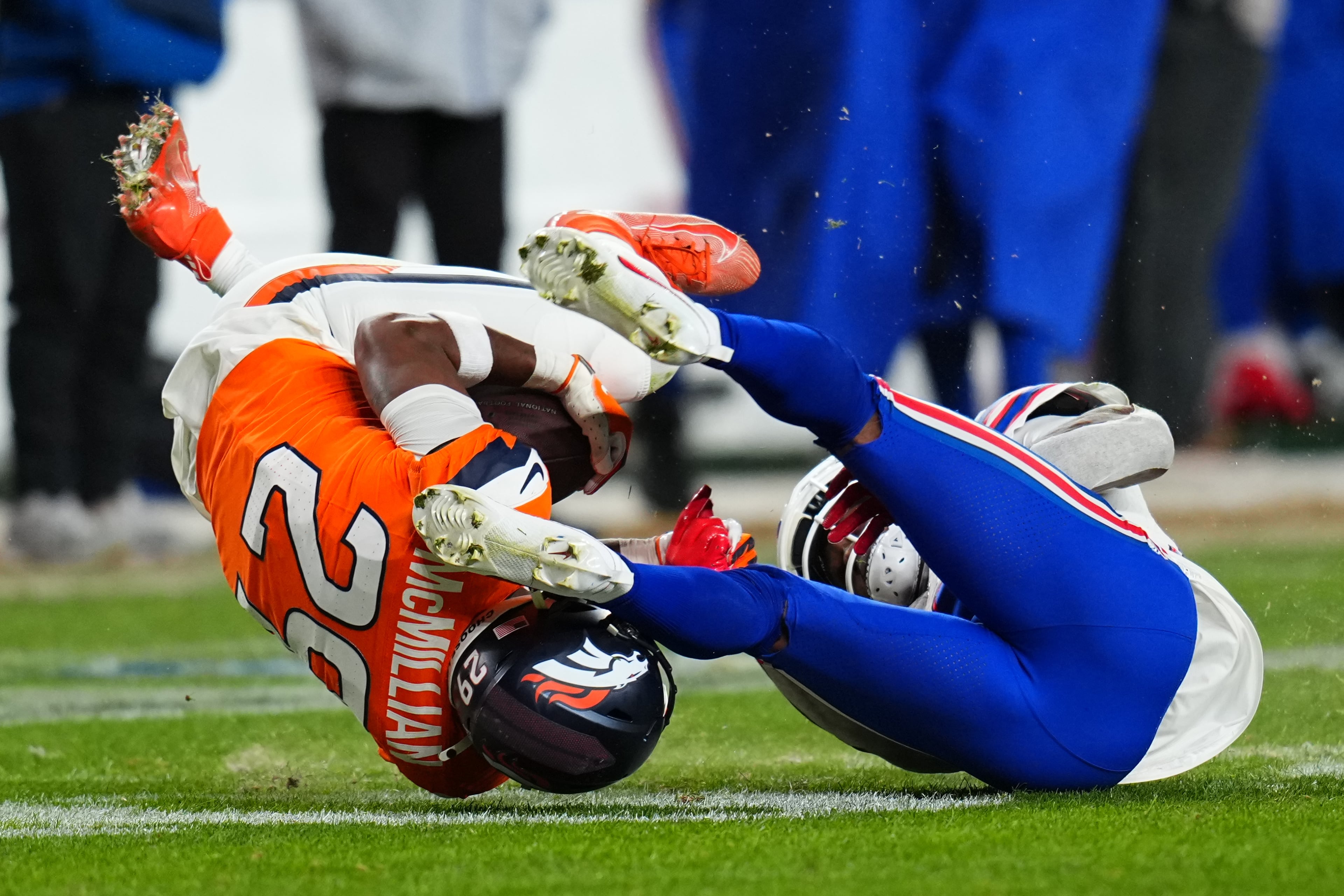 Denver Broncos cornerback Ja'quan McMillian (left) wrangles an overtime pass intended for Buffalo Bills wide receiver Brandin Cooks.