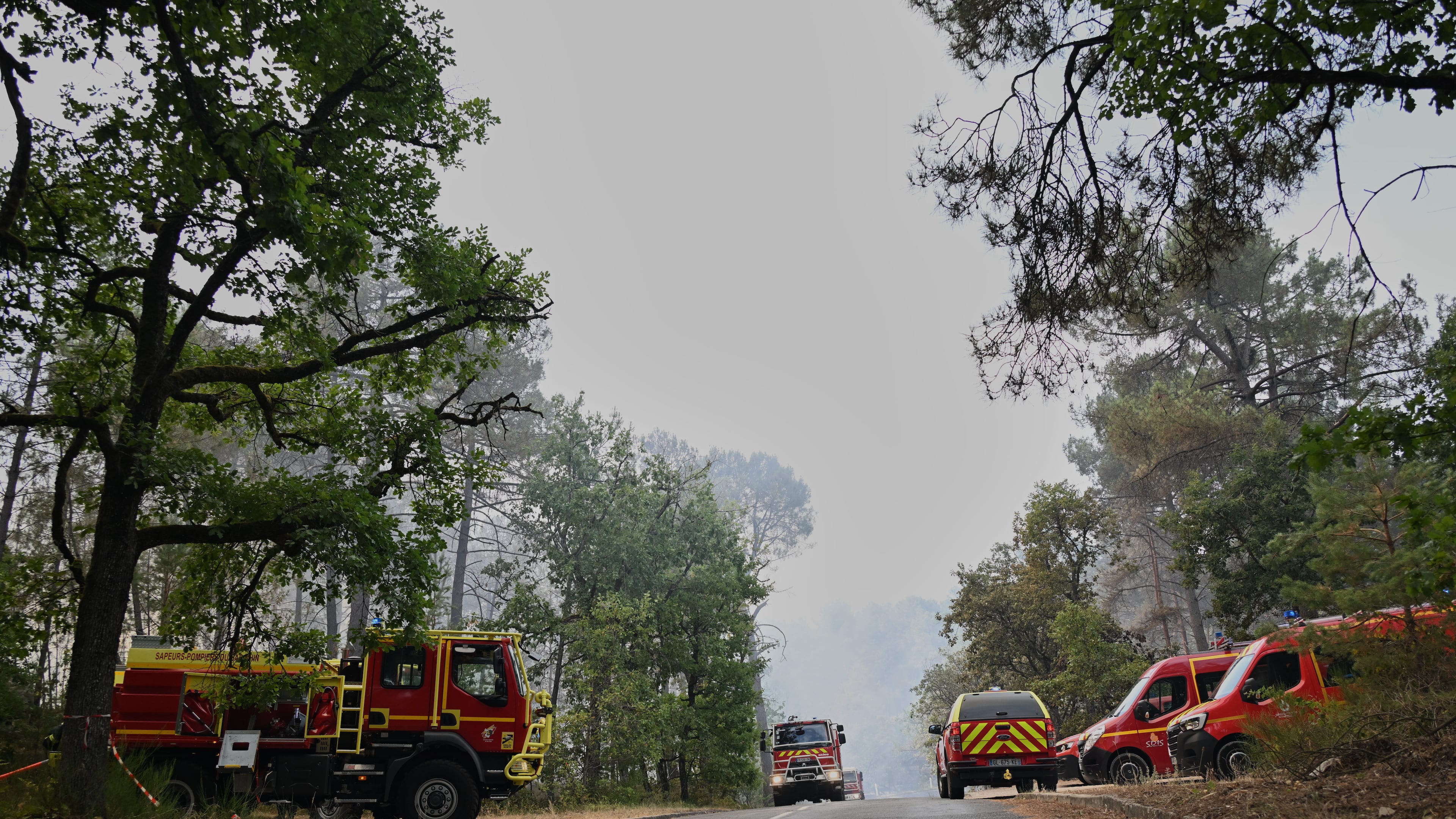 Fire trucks are parked near the scene of a wildfire in the region of the historic Fontainebleau forest, about 60 km (37 miles) south of Paris, France, Monday, July 13, 2026. (AP Photo/Emma Da Silva)