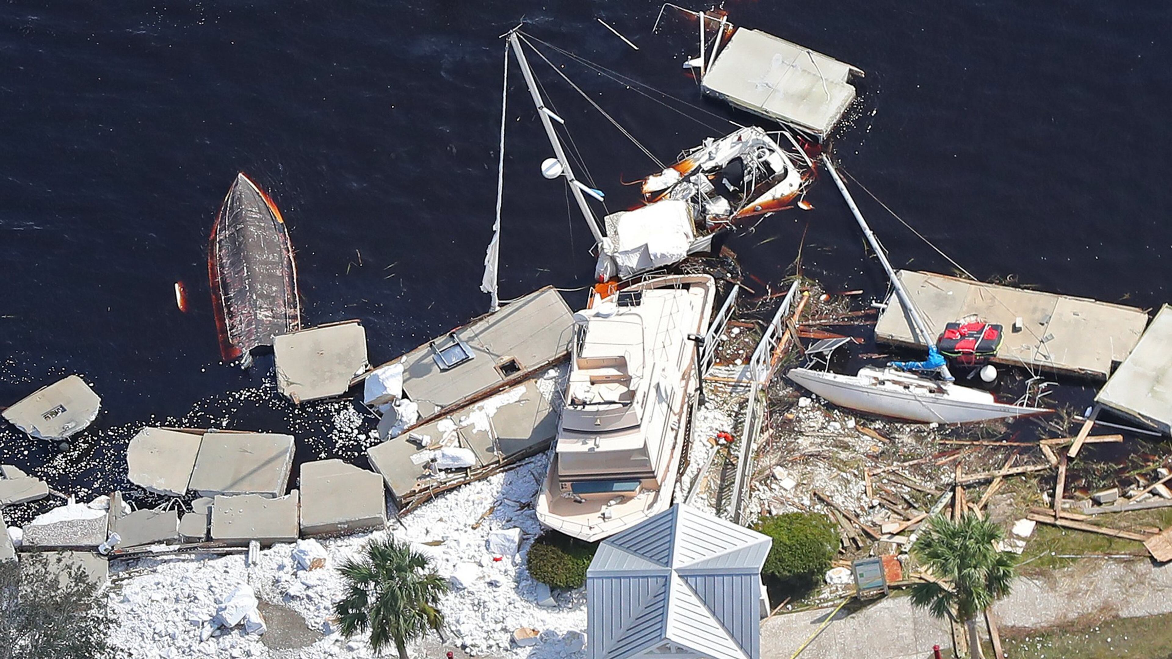 Local residents walk past debris from docks that were shredded and boats that were sunk littering the shoreline after Hurricane Irma on Tuesday, September 12, 2017, at St. Marys on the Georgia coast. Curtis Compton / ccompton@ajc.com
