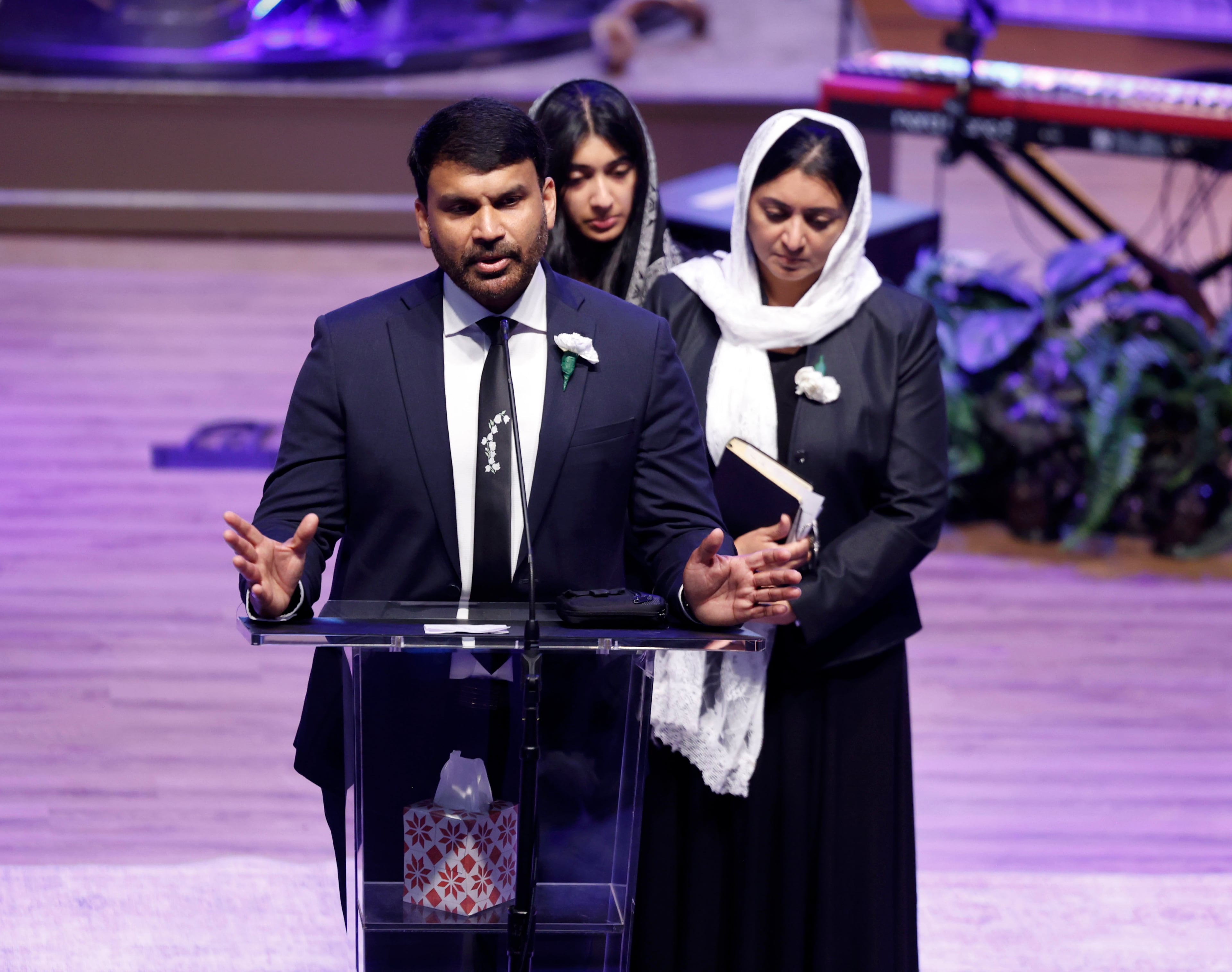 Fiji George speaks at his son's funeral while his wife and daughter stand behind him. His son, Dave Fiji, was killed in a helicopter crash. (Akili-Casundria Ramsess for the AJC)