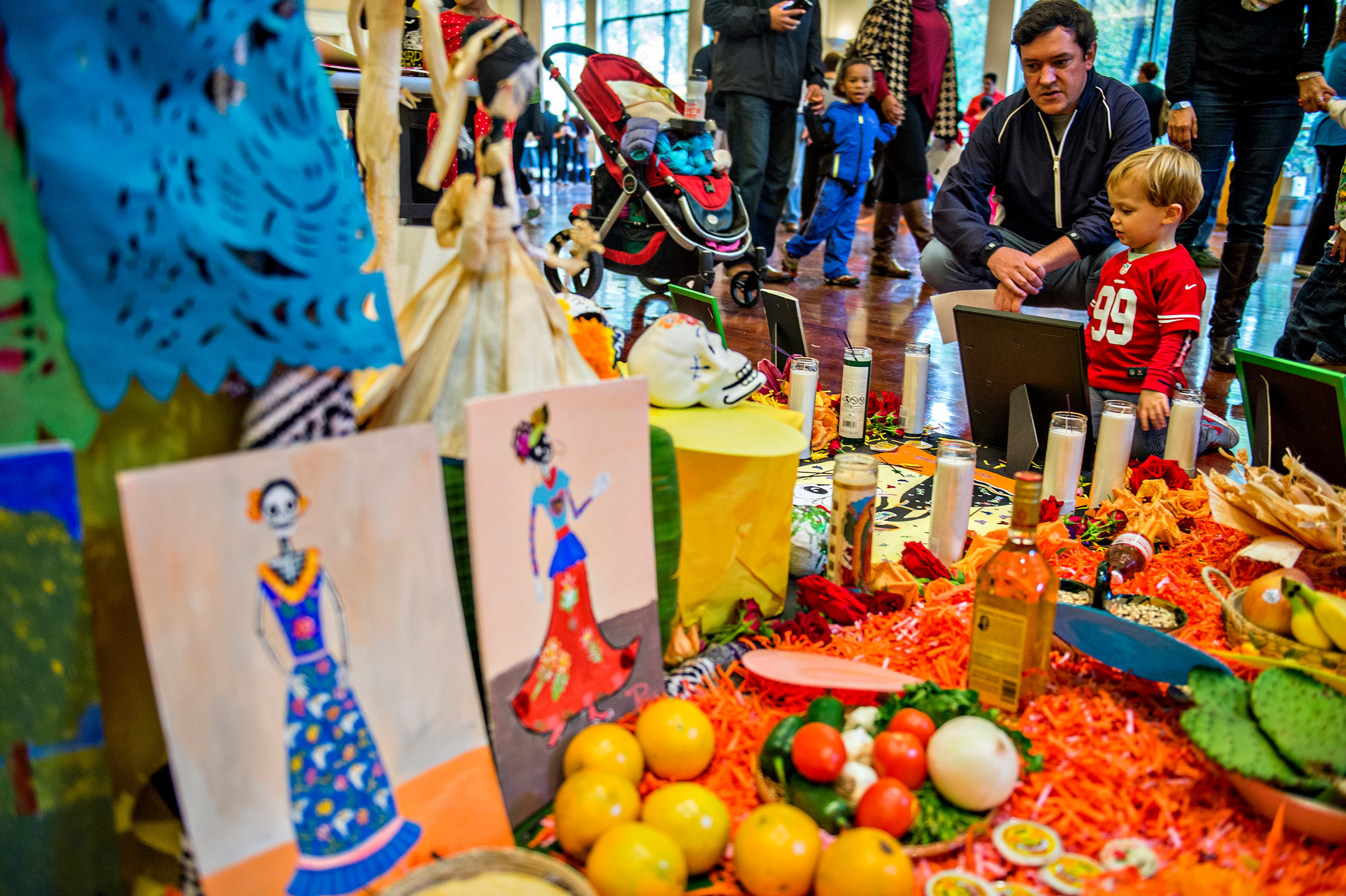 November 1, 2015 Atlanta - Jay Roby (left) explains the candles, food, pictures and other decorations to his son Ryan during the Dia De Muertos, or Day of the Dead, Festival at the Atlanta History Center on Sunday, November 1, 2015. The festival featured storytelling, crafts, and authentic Mexican food and entertainment while teaching about the day that traditionally honors dead friends and loved ones. JONATHAN PHILLIPS / SPECIAL