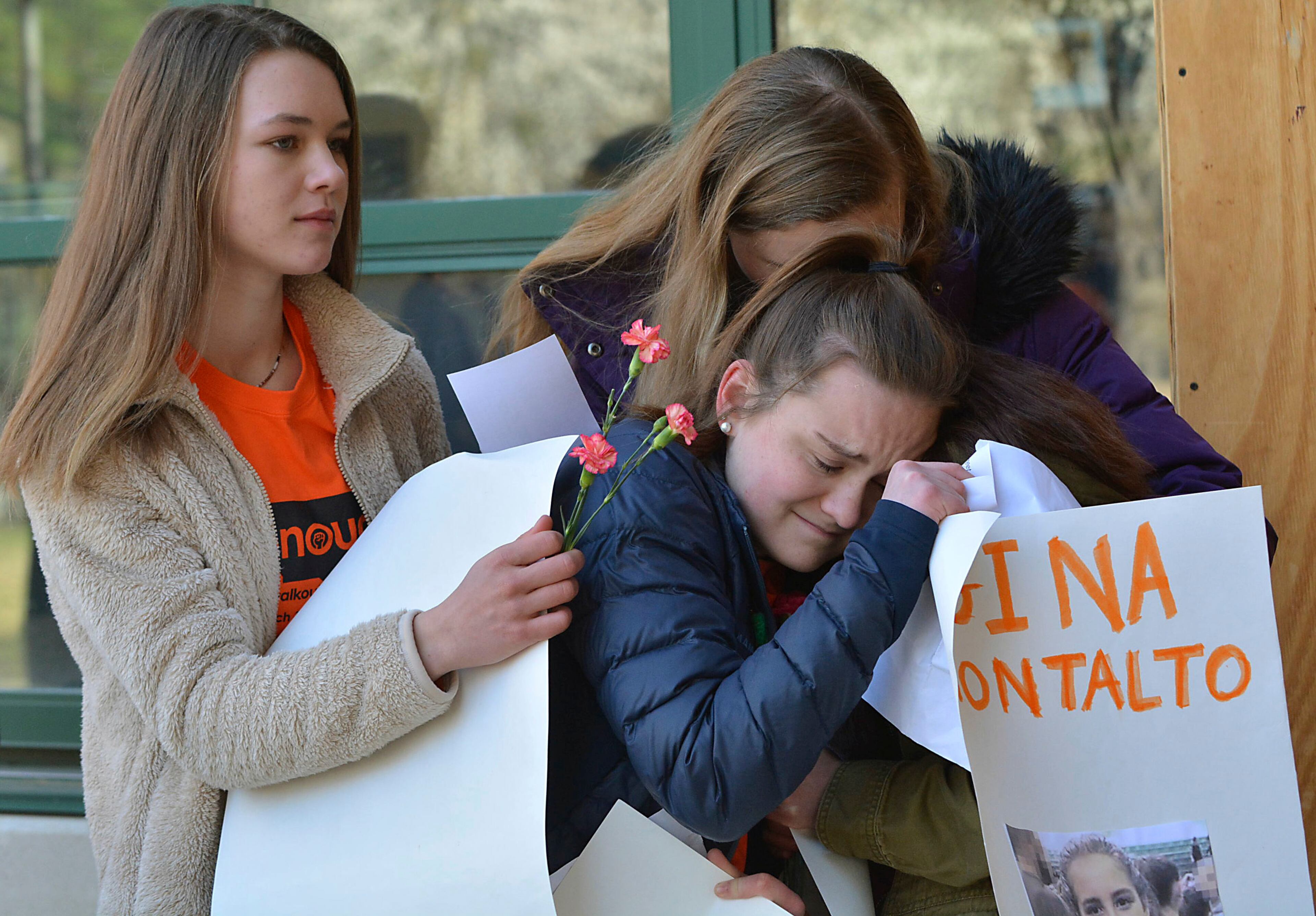 East chapel Hill students hug as they take part in a student walkout on Wednesday, March 14, 2018, in Chapel Hill, N.C. Students across the country participated in walkouts Wednesday to protest gun violence, one month after a deadly shooting inside a high school in Parkland, Fla. (Bernard Thomas/The Herald-Sun via AP)
