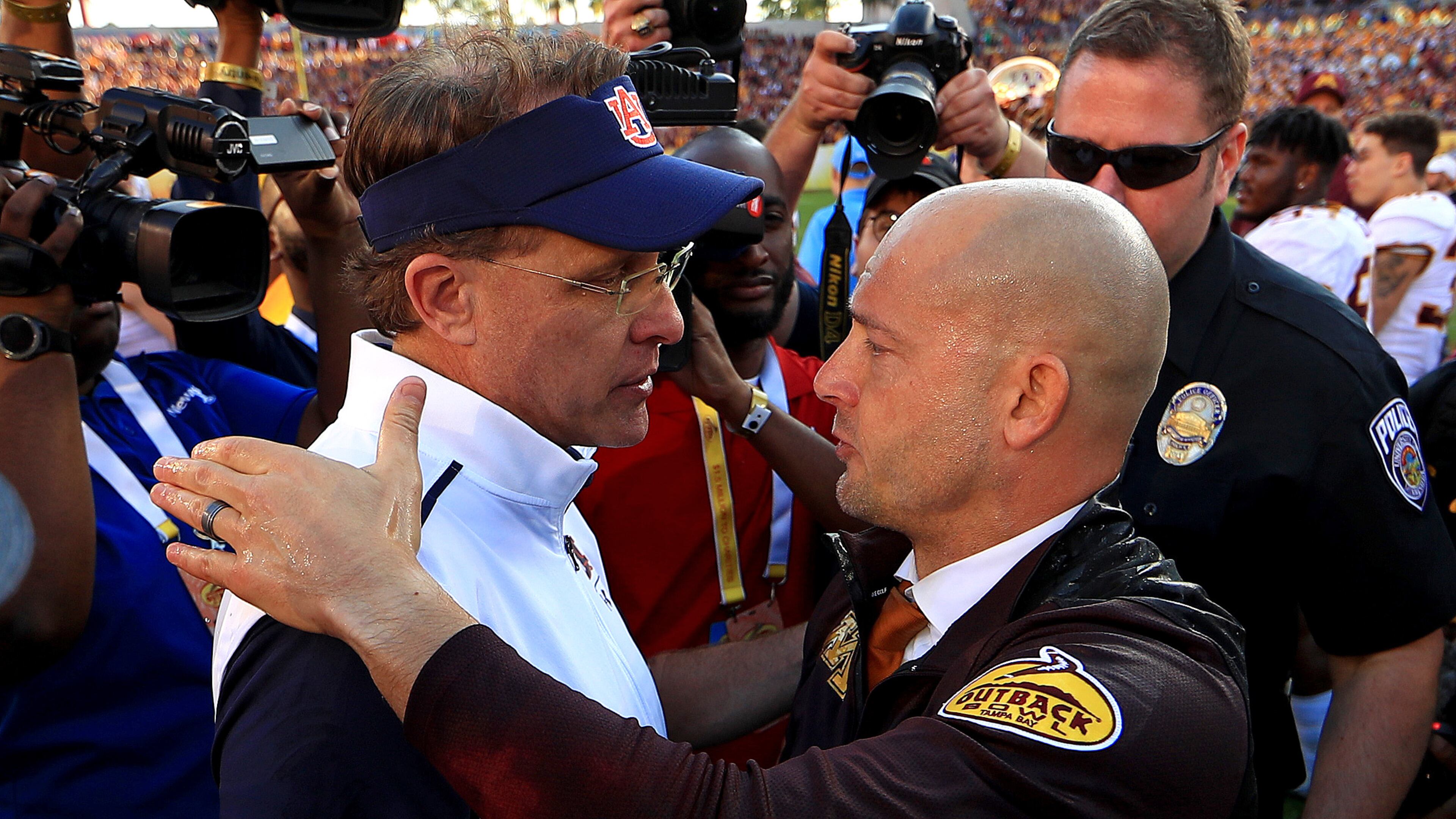 Auburn coach Gus Malzahn (left) shakes hands with Minnesota's P.J. Fleck after the game. (Photo by Mike Ehrmann/Getty Images)