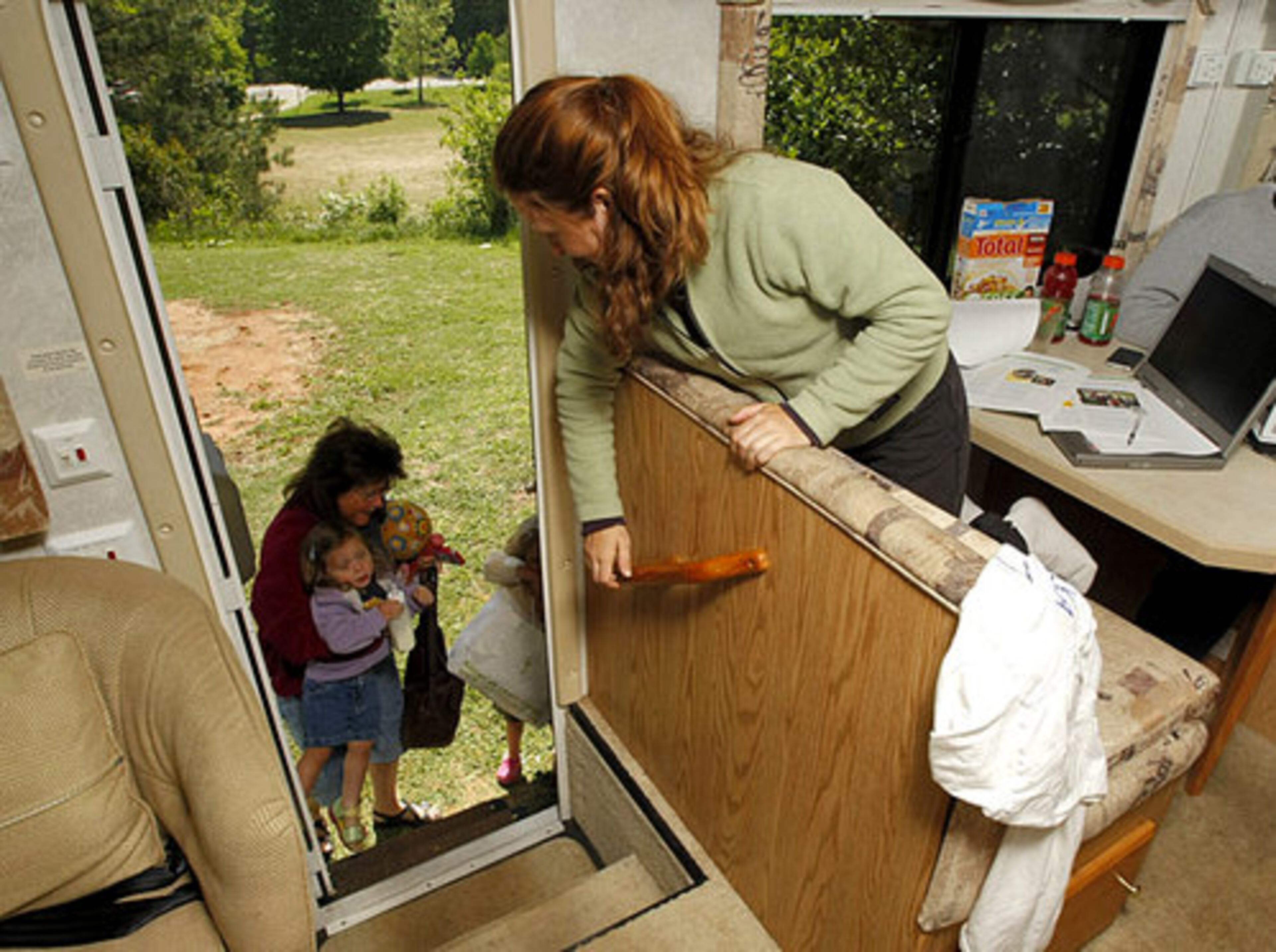 Susan Sheppard helps her granddaughters, Delia Schroeder and Zephy, up the stairs as mother of the two, Christi Schroeder, (right) waits inside a RV.