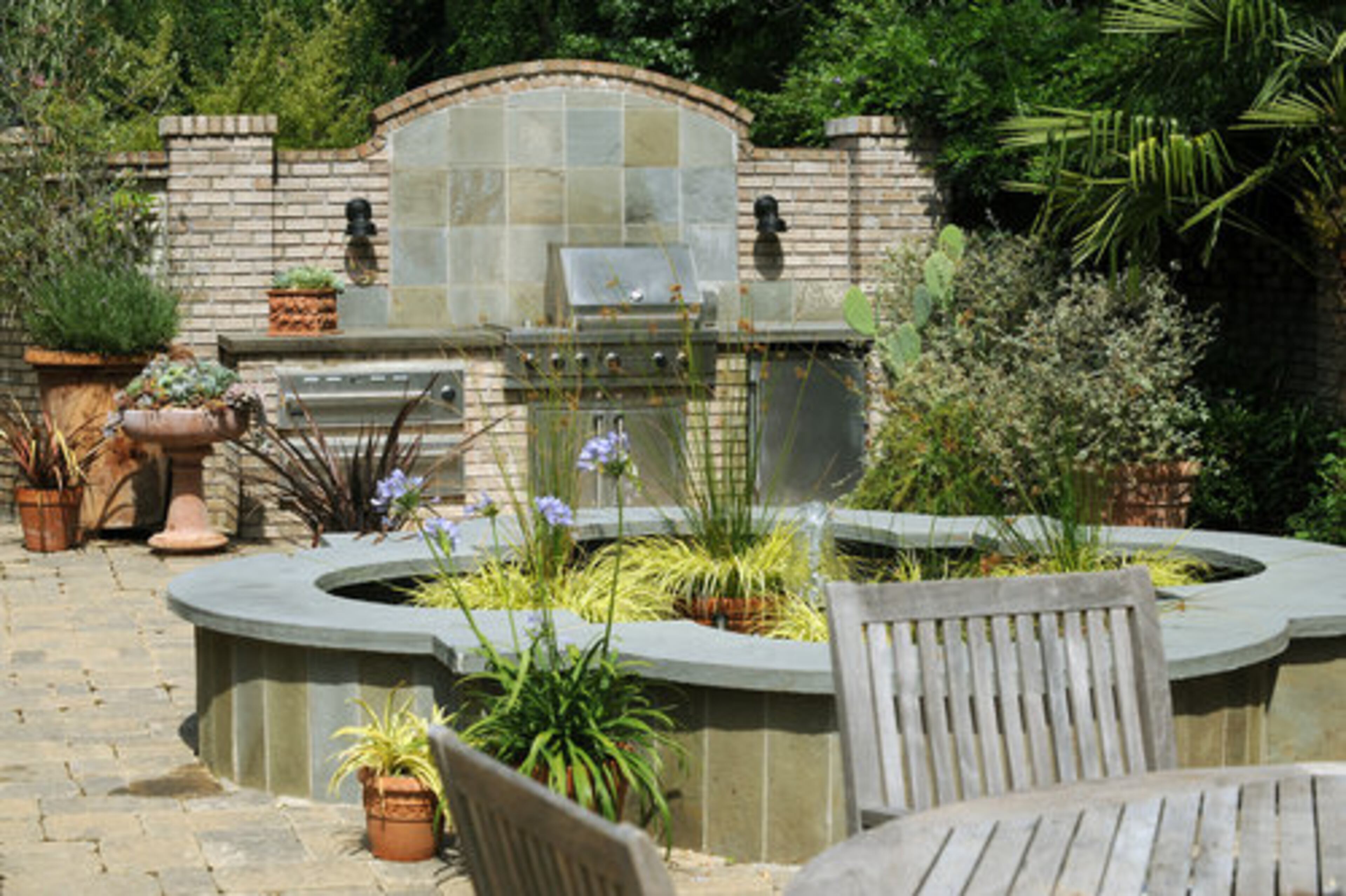 Married for 23 years, the gardening duo loves spending time outside in their outdoor kitchen with their two teenaged daughters, Andrea, 13 and Ali, 15. "We spend more time outside than we do in," David said. Spike plants and cacti abound in container plants, as well as the four leaf clover-shaped water feature.