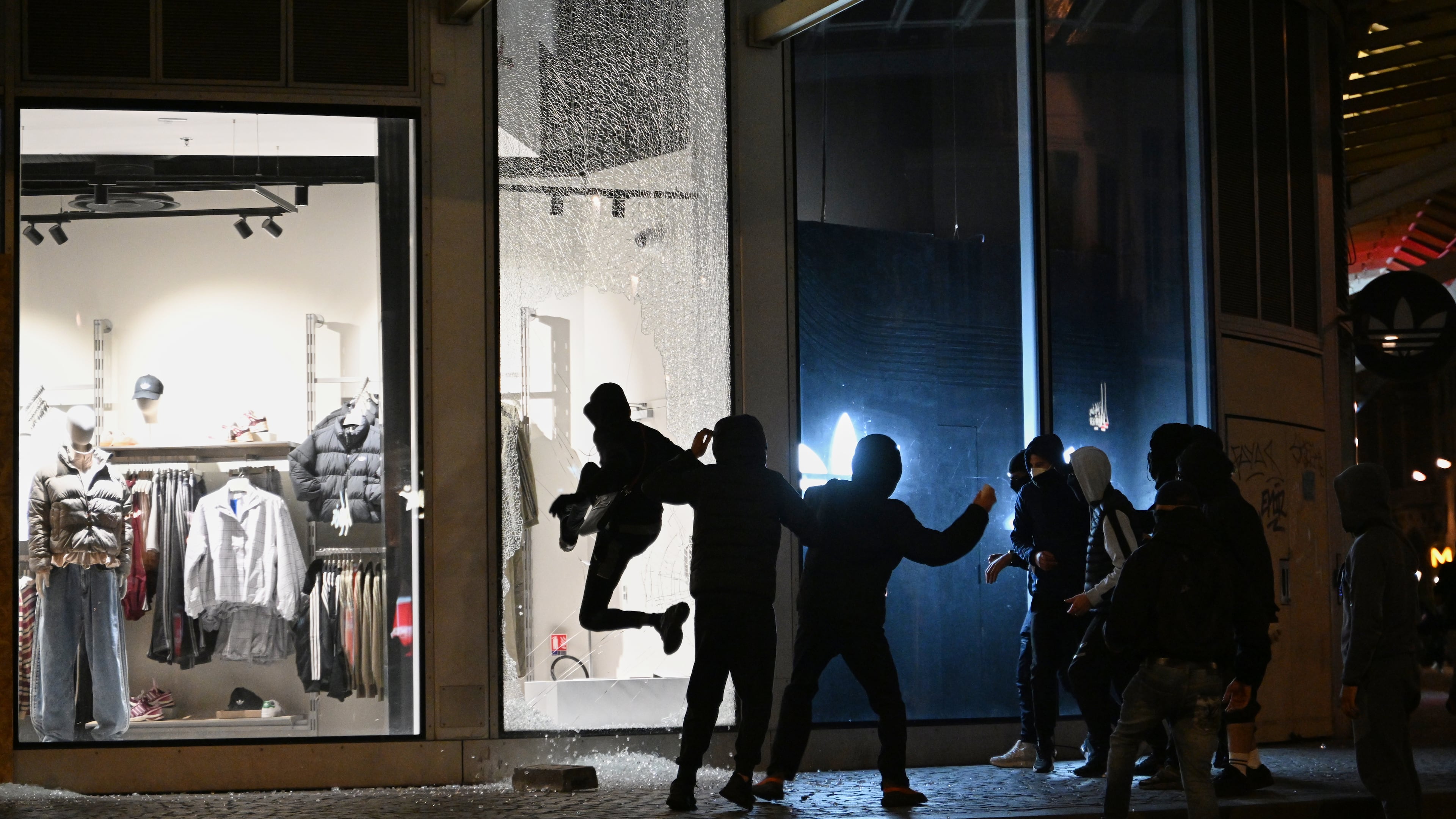 Youths break a store window during clashes between protestors and police in Paris, Sunday, Oct. 18, 2026. (AP Photo/Emma Da Silva)