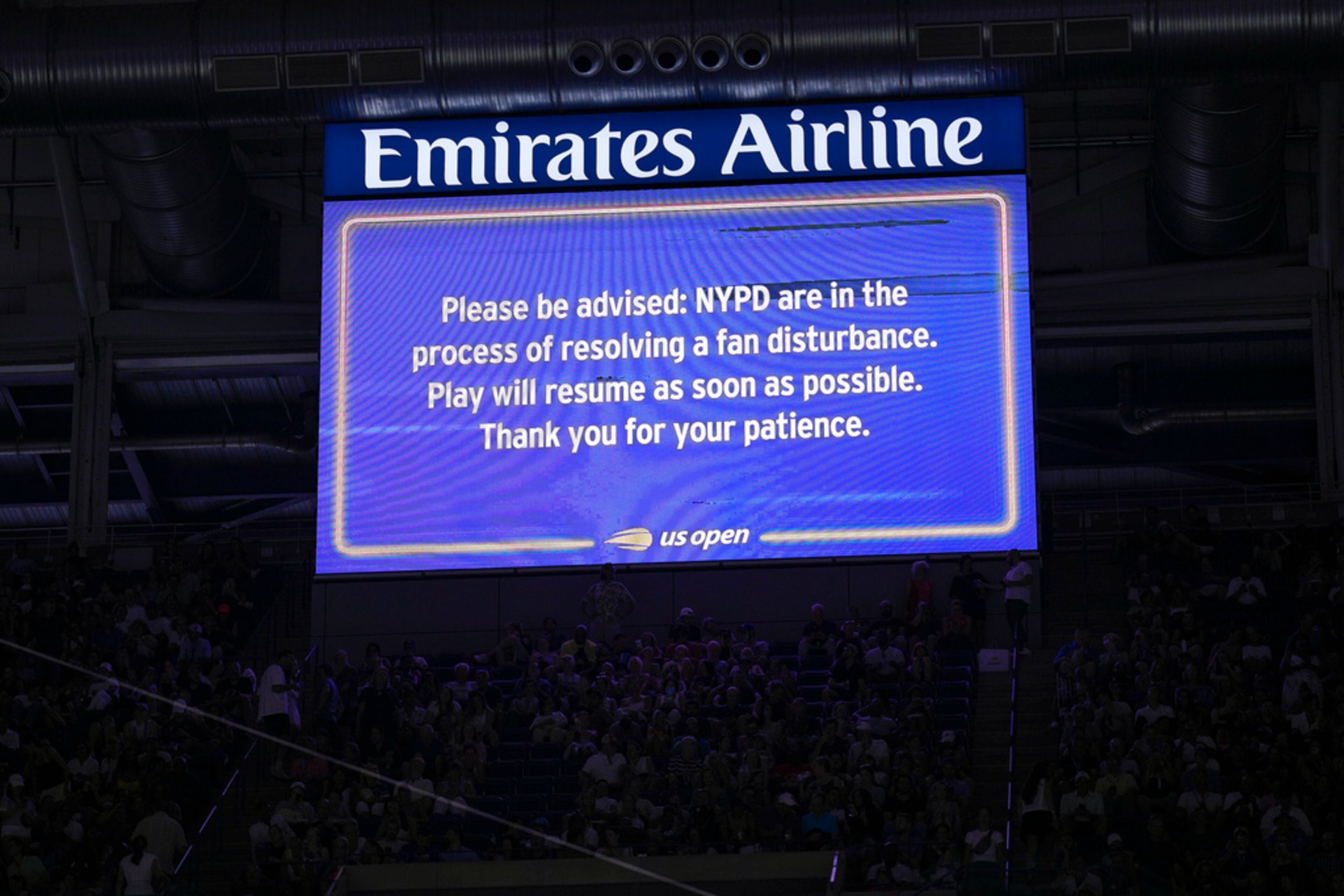 An advisory about a disruption in play is displayed on the large screen inside Arthur Ashe Stadium during play between Karolina Muchova, of the Czech Republic, and Coco Gauff, of the United States, during the women's singles semifinals of the U.S. Open tennis championships, Thursday, Sept. 7, 2023, in New York. (AP Photo/Manu Fernandez)