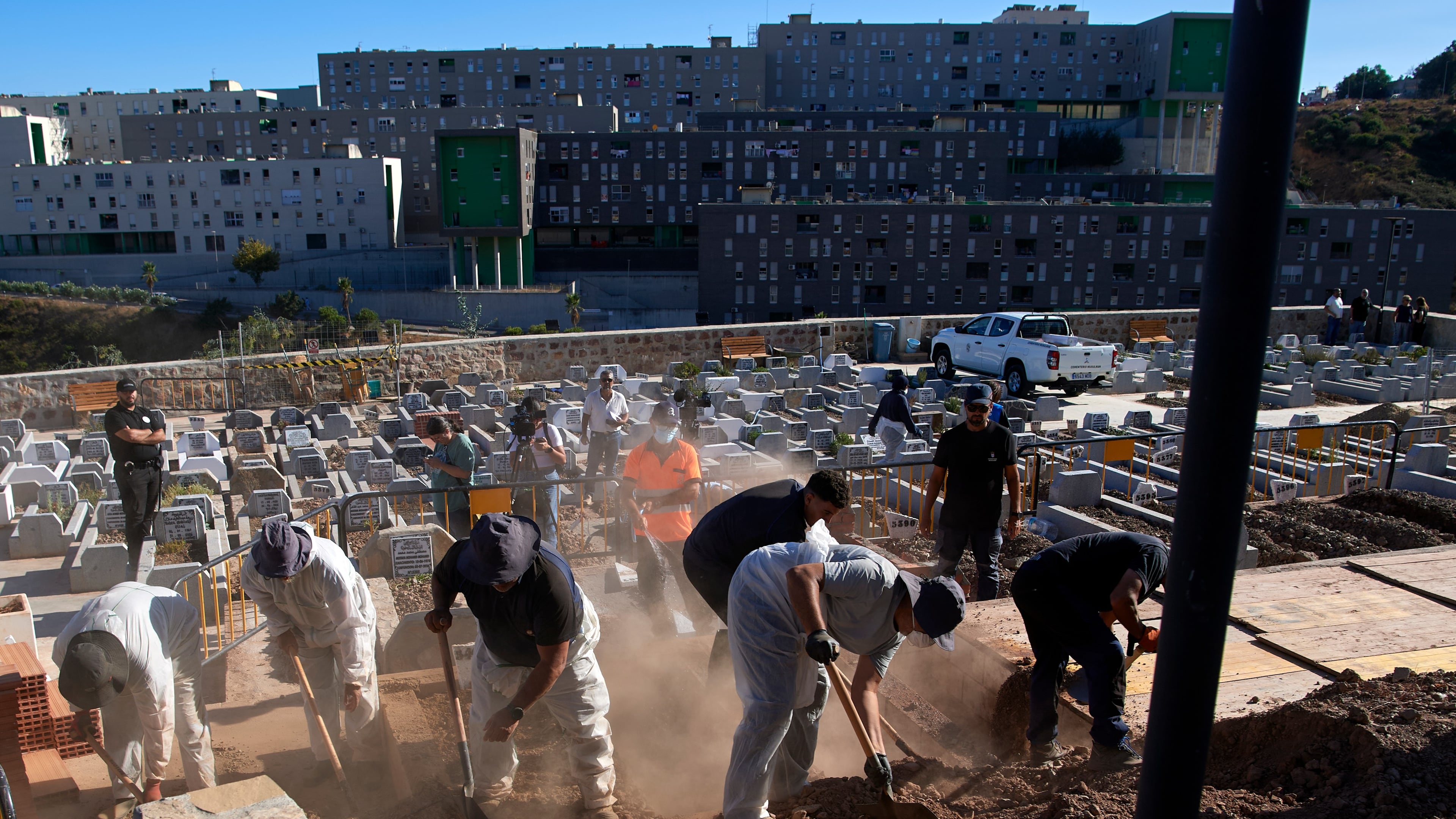 Funeral workers bury migrants who died while trying to cross from Morocco into the Spanish exclave of Ceuta, Friday, Aug. 21, 2026. (AP Photo/Antonio Sempere)