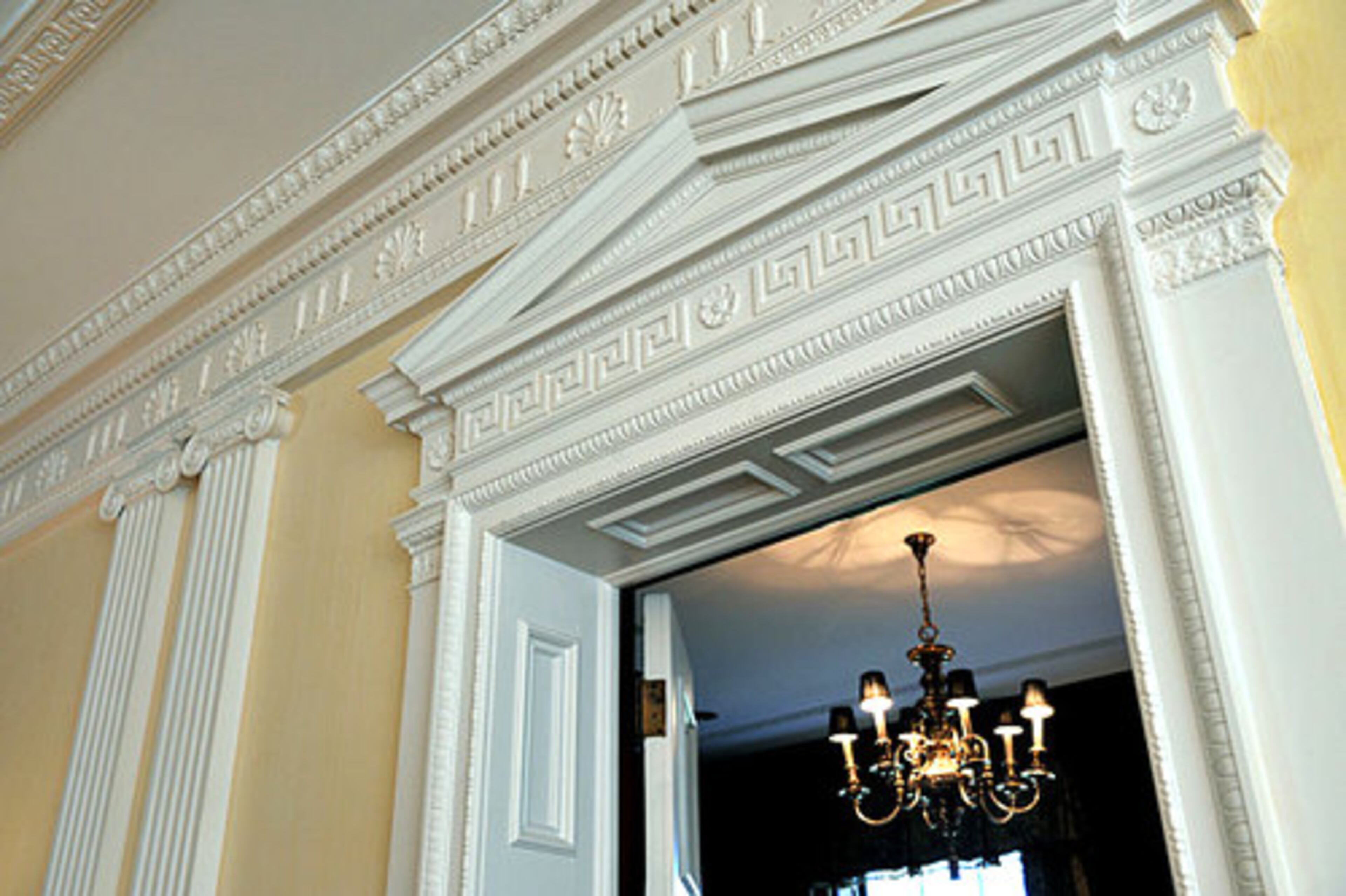 The intricate molding shows off the home's classical Regency design. This is a doorway in the main living room that leads to the study.
