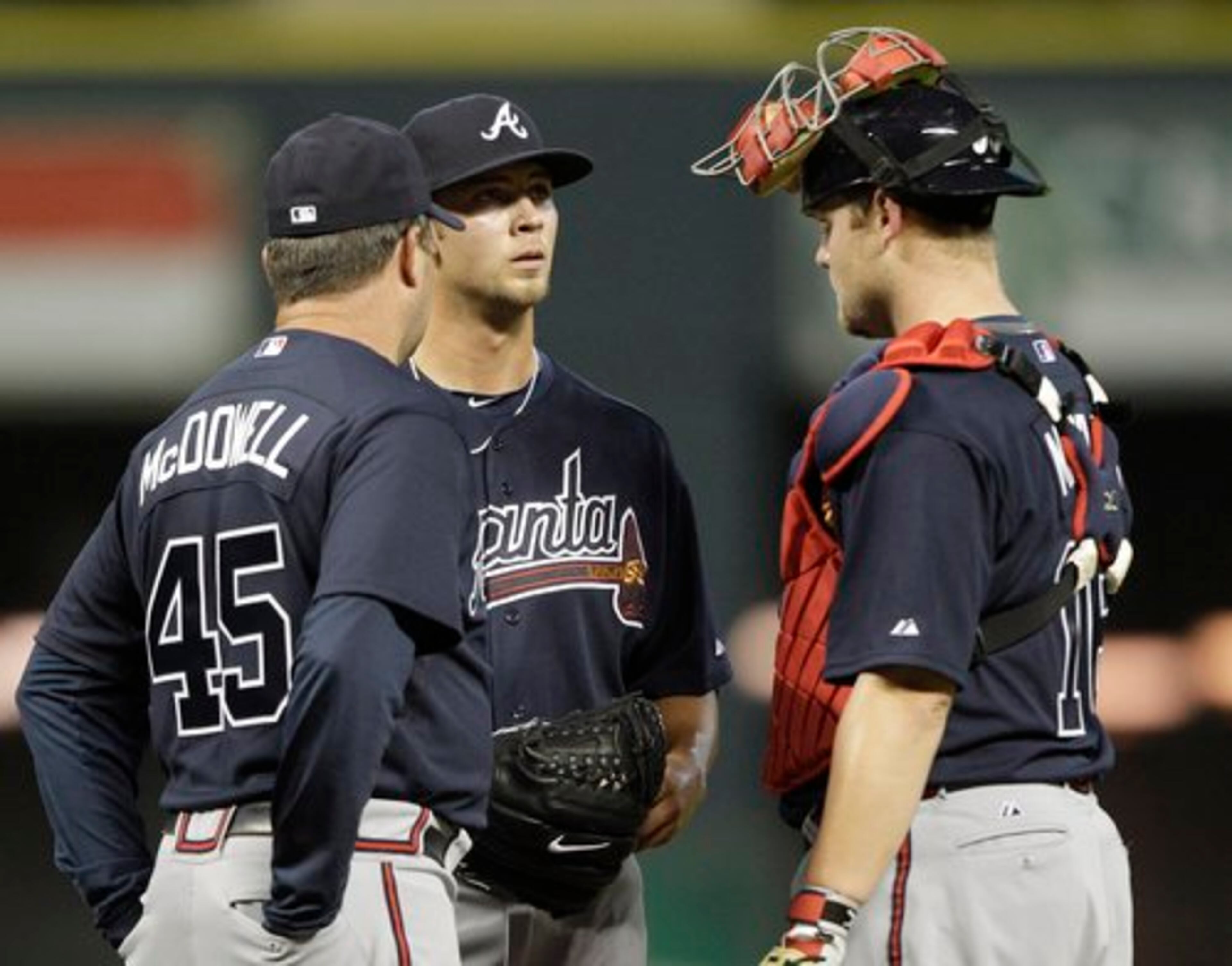 Atlanta Braves pitching coach Roger McDowell (45) talks with pitcher Mike Minor, center, and catcher Brian McCann, right, during the fourth inning of a baseball game against the Houston Astros Monday, Aug. 9, 2010 in Houston.