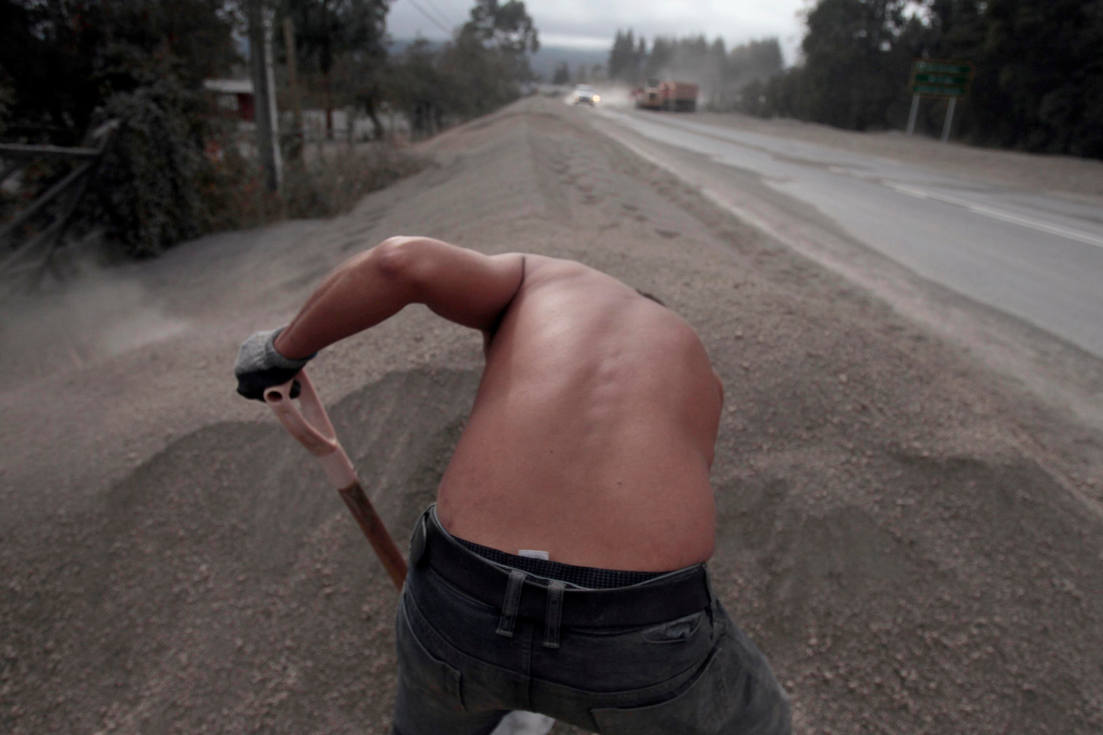 MOVING ASH--Victor hugo Toledo shovels volcanic ash from the eruption of the Calbuco volcano, away from the entrance of his home home in Puerto Varas, Chile, Sunday, April 26, 2015. The Calbuco volcano, which had been dormant for more than four decades, had two huge eruptions this week. The head of the National Mining and Geology Service said the volcano's eruptive process could last weeks and even months and warned that a third eruption was possible. (AP Photo/Luis Hidalgo)