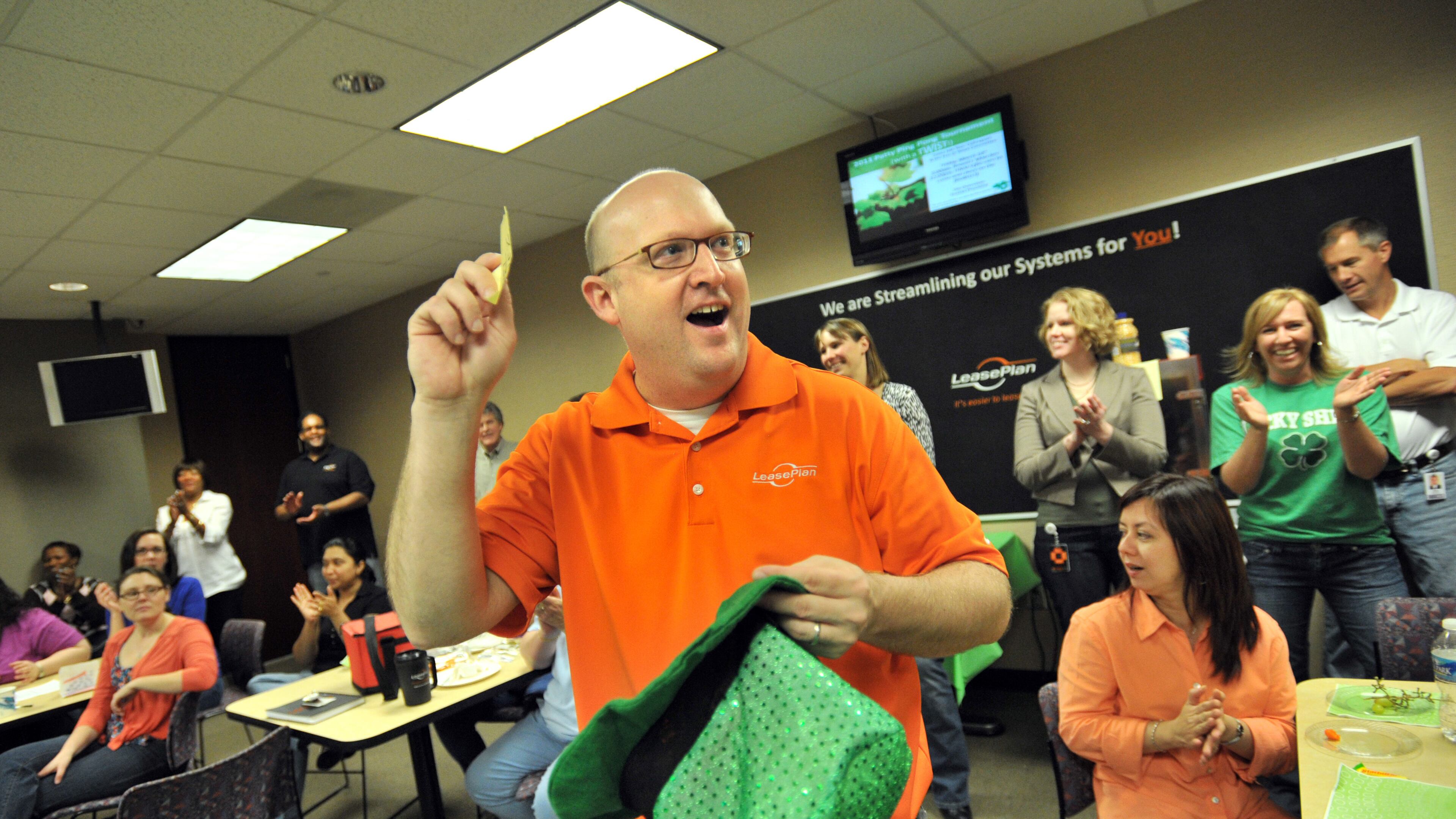 LeasePlan USA human resources director Bill Middleton announces a winner for Braves tickets at the company's Patty's Ping-Pong Tournament, organized by the Fun At Work committee.