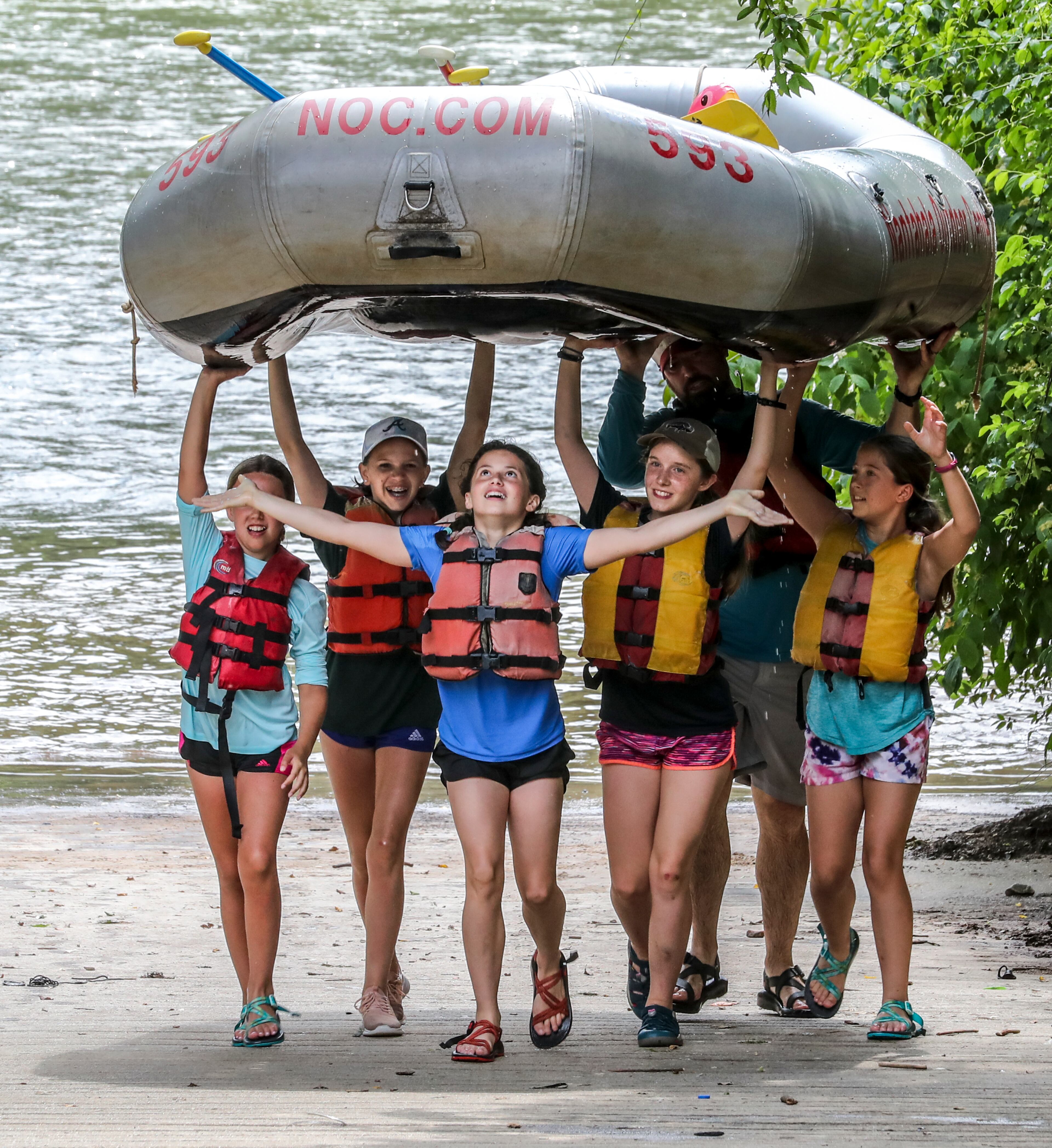 May 31, 2022 Cobb County: Look Ma, no hands! Margot Seelinger-12 a rising 7th grader (center) opens her arms as she and other campers from Trinity Anglican Church in Atlanta bring their raft up the ramp at the Paces Mill boat ramp on the Chattahoochee River located at 3444 Cobb Pkwy SE in Cobb County on Tuesday, May 31, 2022. (John Spink / John.Spink@ajc.com)