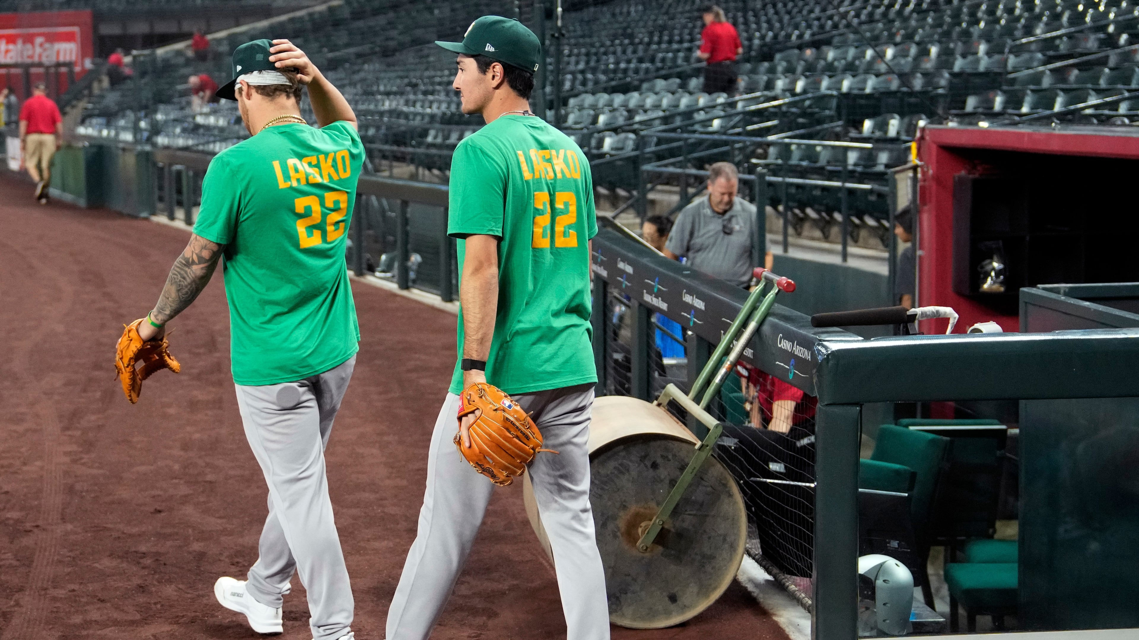 Athletics' Tommy White, left, and Alika Williams wear a Lasko No. 22 t-shirt in honor of injured Athletics minor league player Ryan Lasko prior to a baseball game against the Arizona Diamondbacks, Wednesday, July 22, 2026, in Phoenix. (AP Photo/Ross D. Franklin)