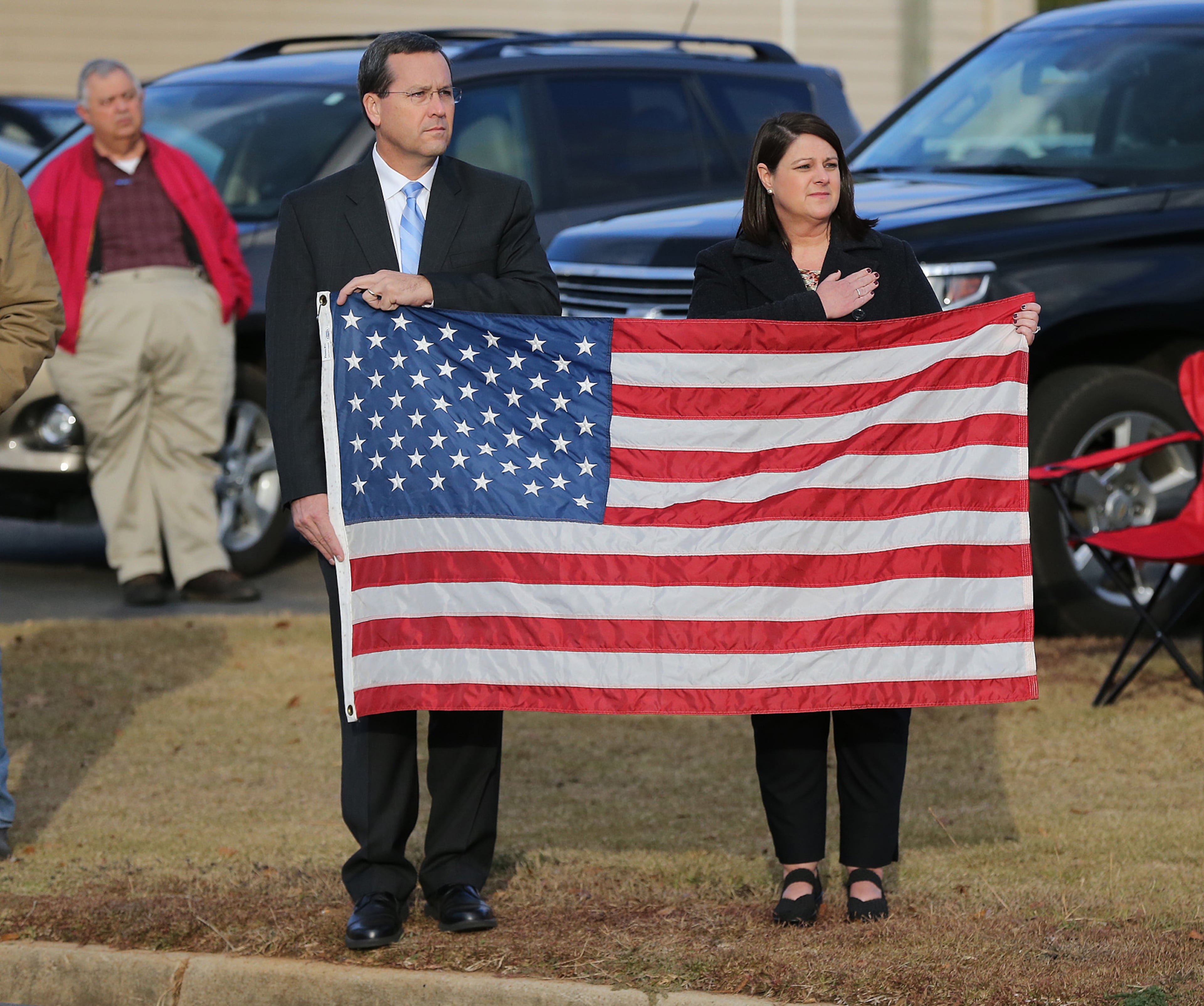 December 11, 2016, AMERICAS: Local citizens hold an American flag looking on as the North Carolina Troopers Association/N.C. Highway Patrol Caison Unit transfers Americus police officer Nicholas Ryan Smarr from his funeral service to Oak Grove Cemetery on Sunday, Dec. 11, 2016, in Americas. Officer Smarr and Georgia Southwestern State University campus police officer Jody Smith were killed responding to a domestic dispute. Curtis Compton/ccompton@ajc.com