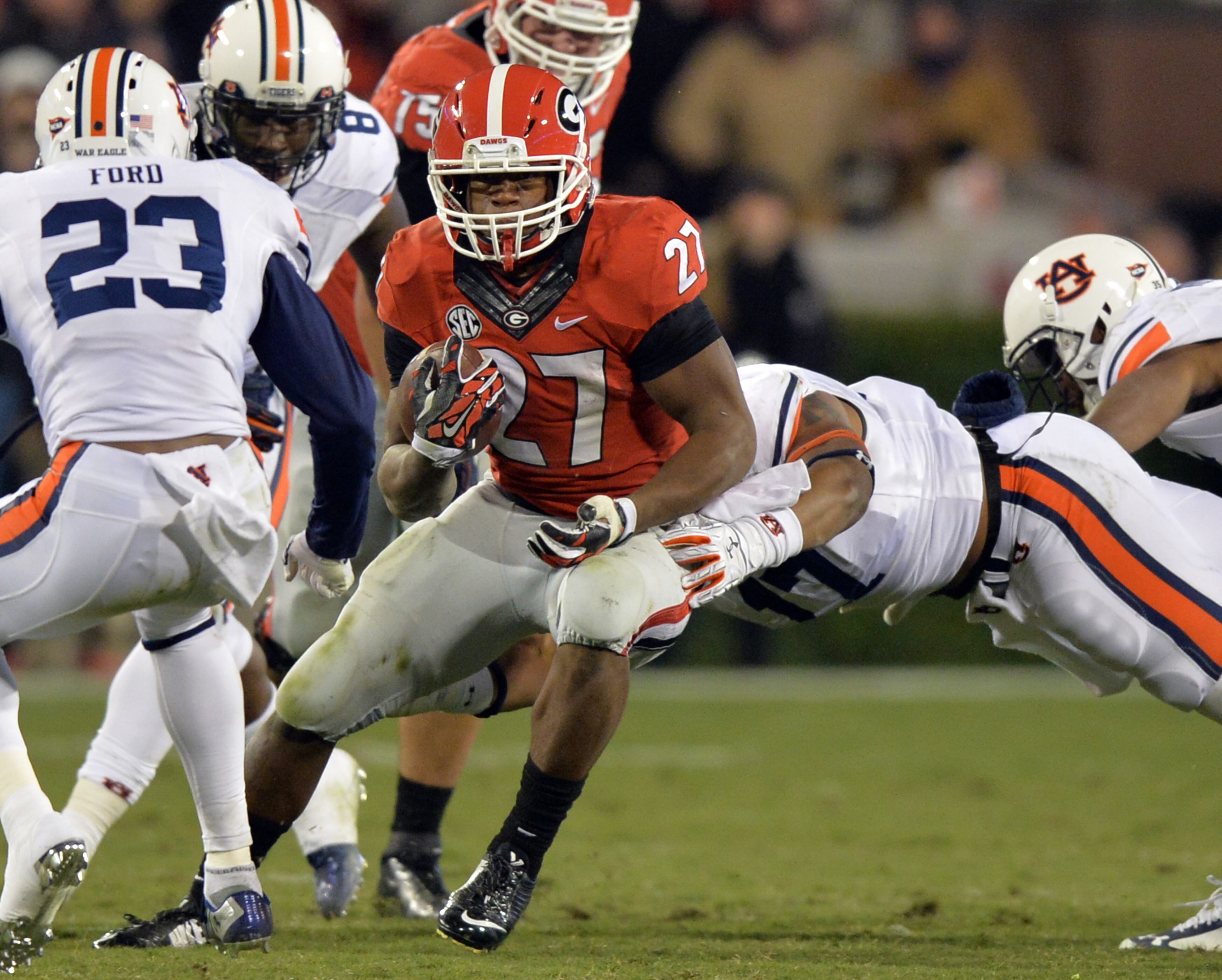 Georgia Bulldogs running back Nick Chubb looks for extra yardage as he is hit by Auburn Tigers linebacker Kris Frost during the third quarter on Saturday, Nov. 15, 2014.