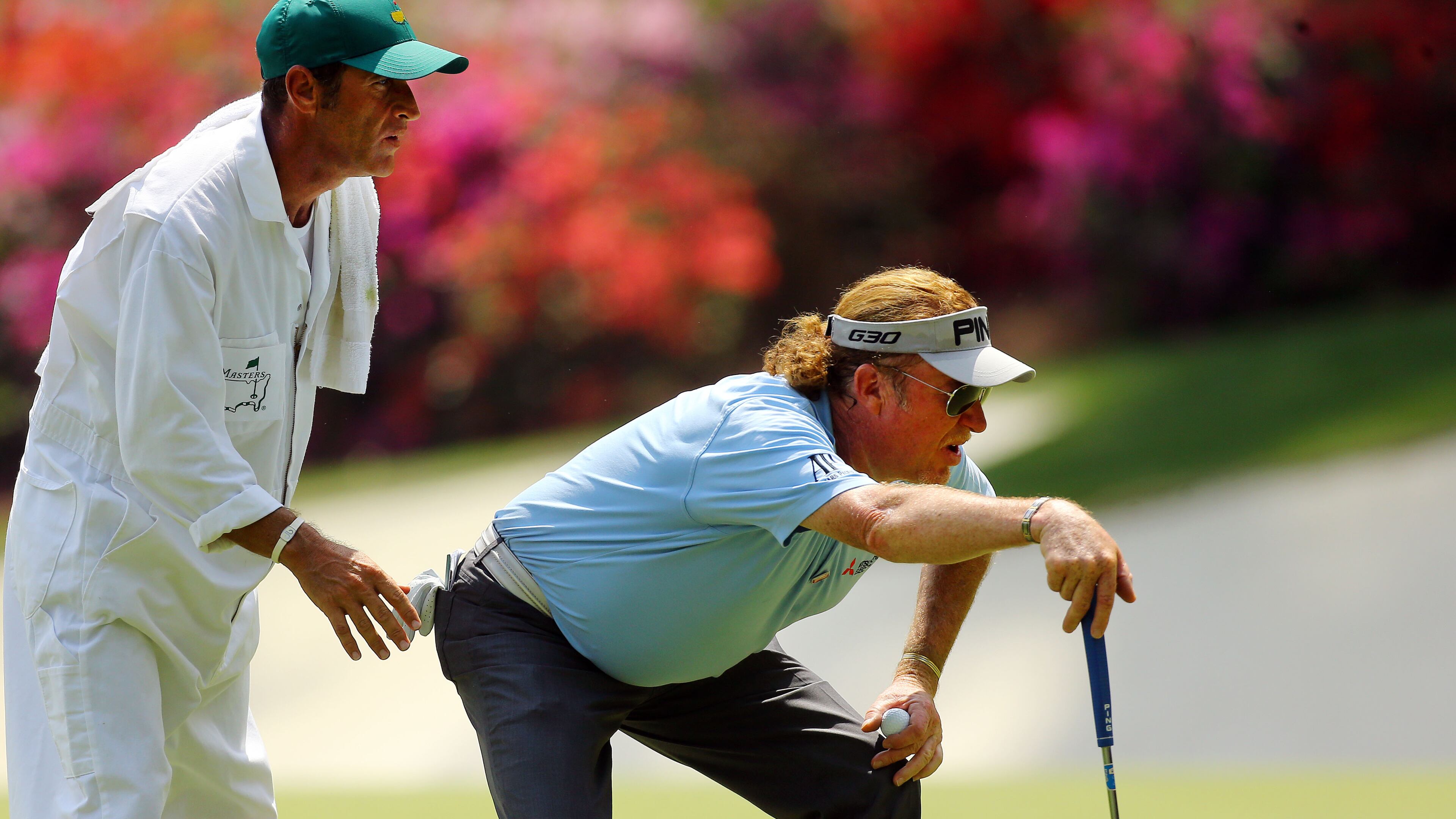 Miguel Angel Jimenez and his caddie, Clifford Botha, check his shot on the #13 green. Photos from the first round at the Masters Golf Tournament, Thursday, April 9, 2015. CURTIS COMPTON/CCOMPTON@AJC.COM