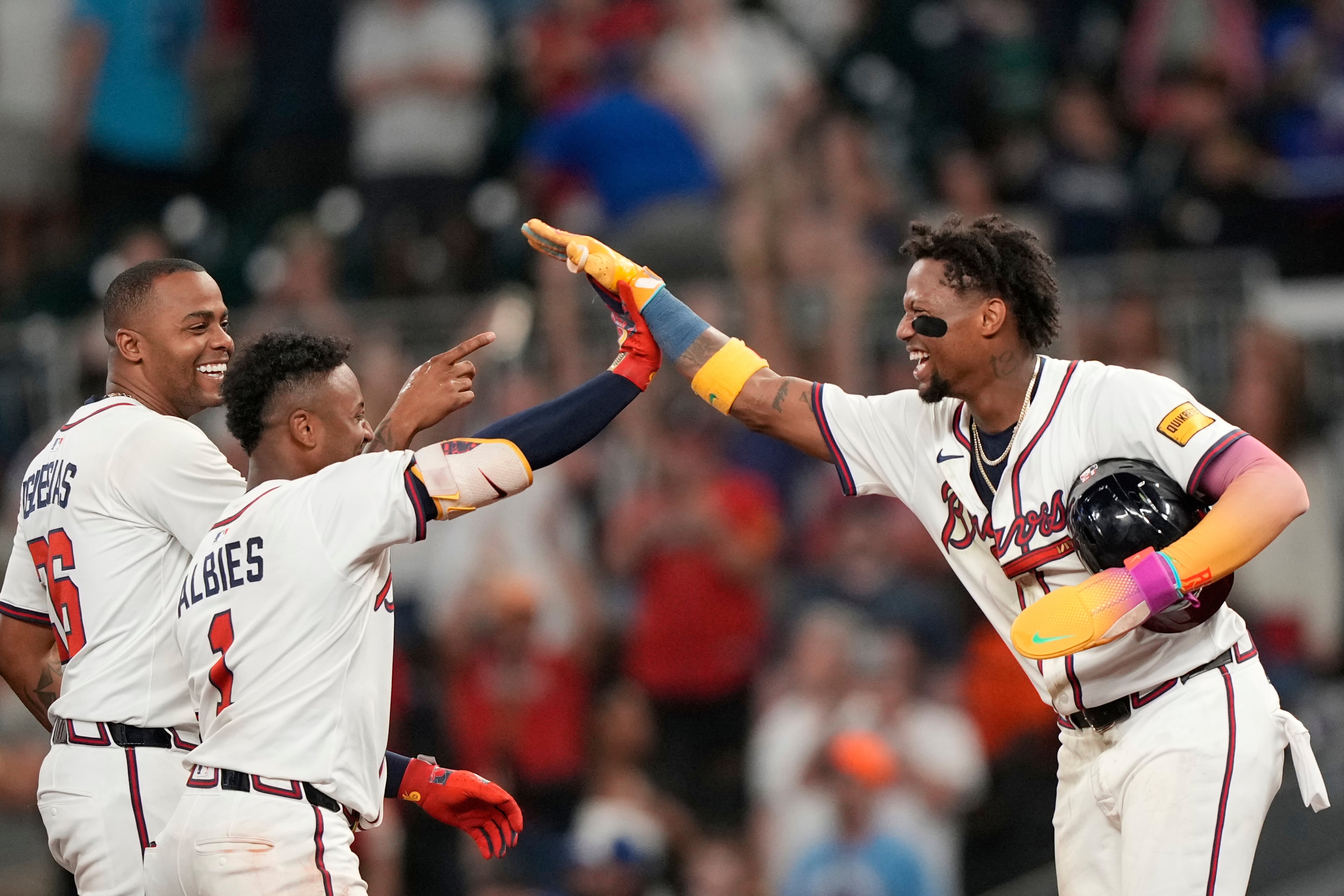The Braves' Ronald Acuña Jr. (right) celebrates a win against the New York Mets with Ozzie Albies (1) and pitcher Raisel Iglesias (26) on Tuesday, June 17, 2025, in Atlanta. (Brynn Anderson/AP)