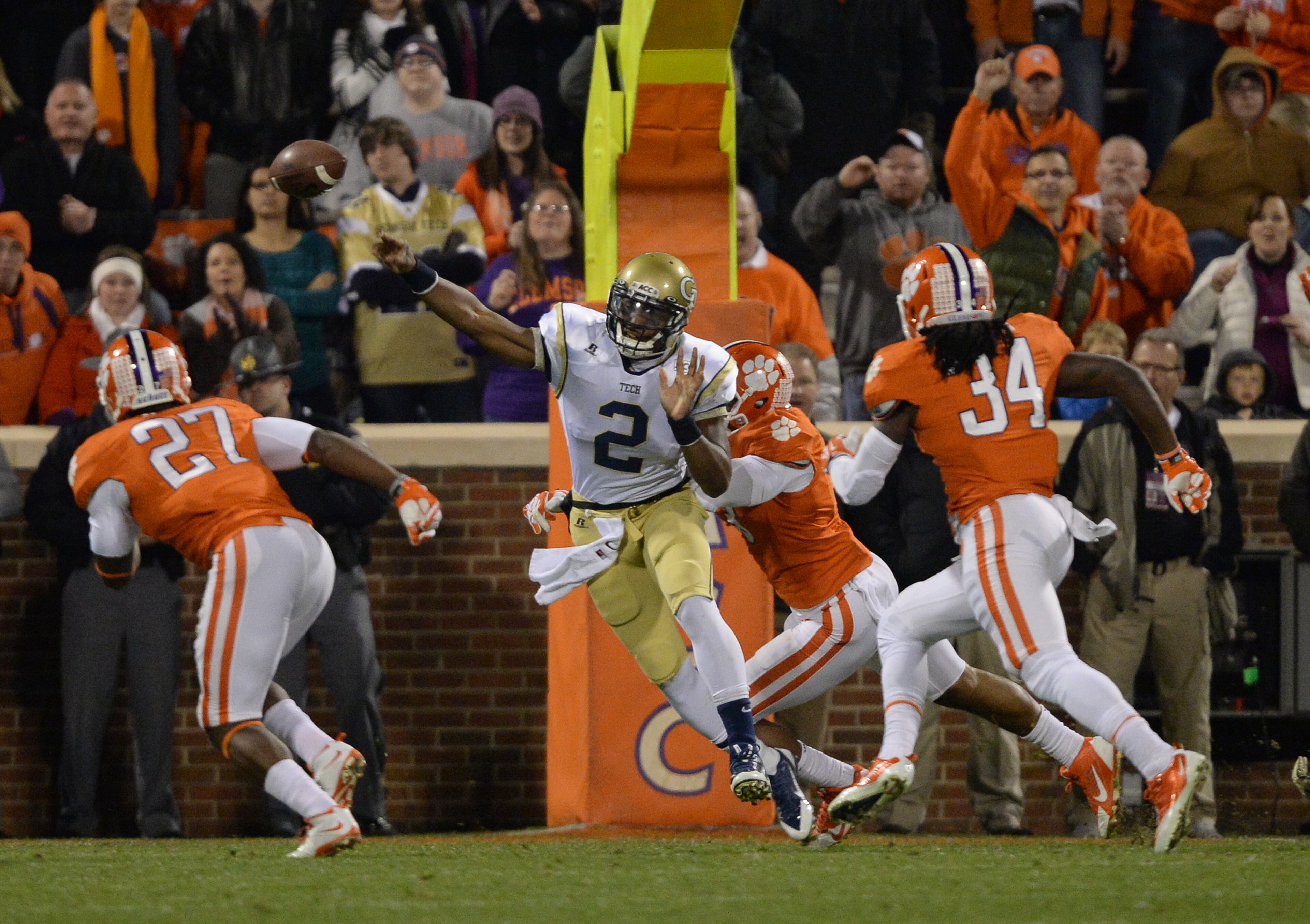 Georgia Tech's Vad Lee (2) is hit from behind by a Clemson defensive player as he throws the football in the first quarter inside Clemson Memorial Stadium in Clemson, S.C. on Thursday, Nov. 14, 2013.