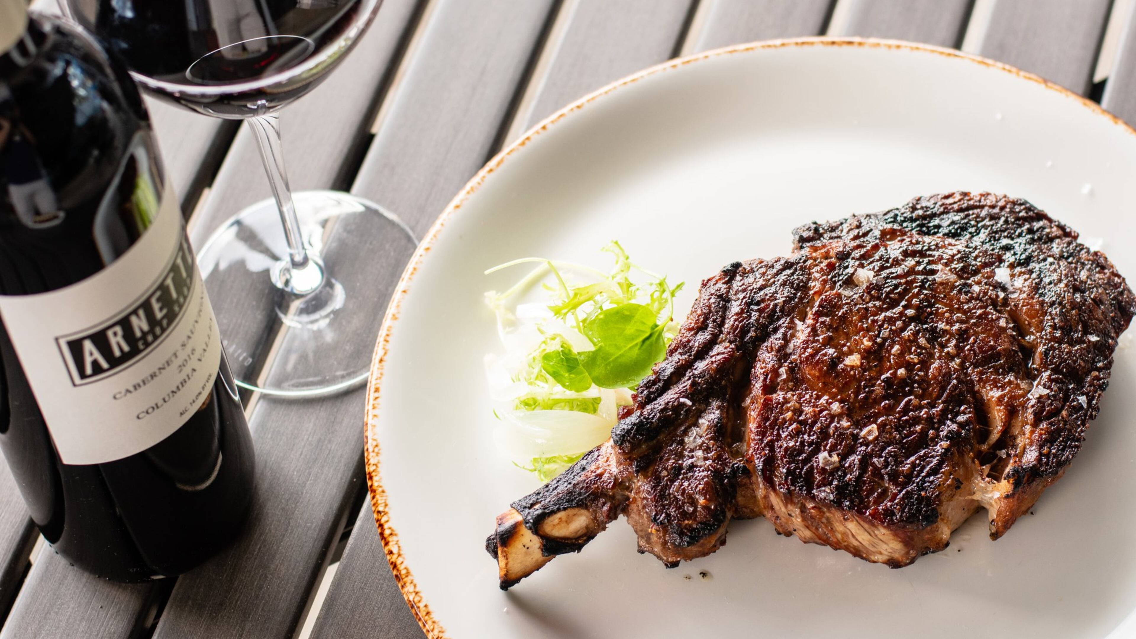 Although Arnette’s Chop Shop in Brookhaven is closed for dine-in service, customers still can enjoy its steakhouse fare, like a 22-ounce cowboy rib-eye (pictured), paired with the house label red wine. CONTRIBUTED BY HENRI HOLLIS