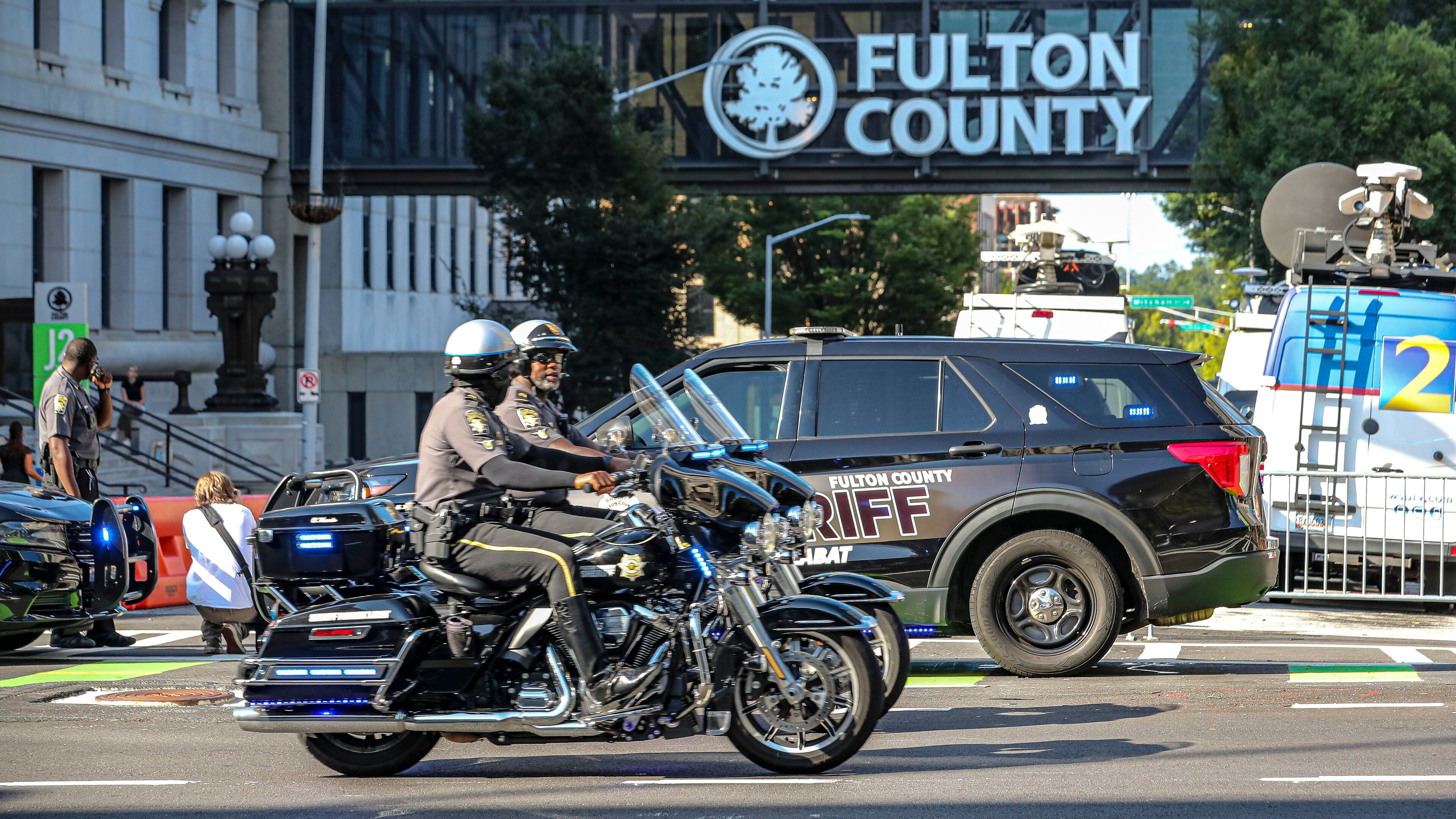 On Monday, Fulton County Sheriff's cruisers and deputies on motorcycles block the entrances to Pryor Street in the block in front of the Fulton County Courthouse entrance, where the case against former president Donald Trump and others was being presented before the grand jury. (John Spink/The Atlanta Journal-Constitution)