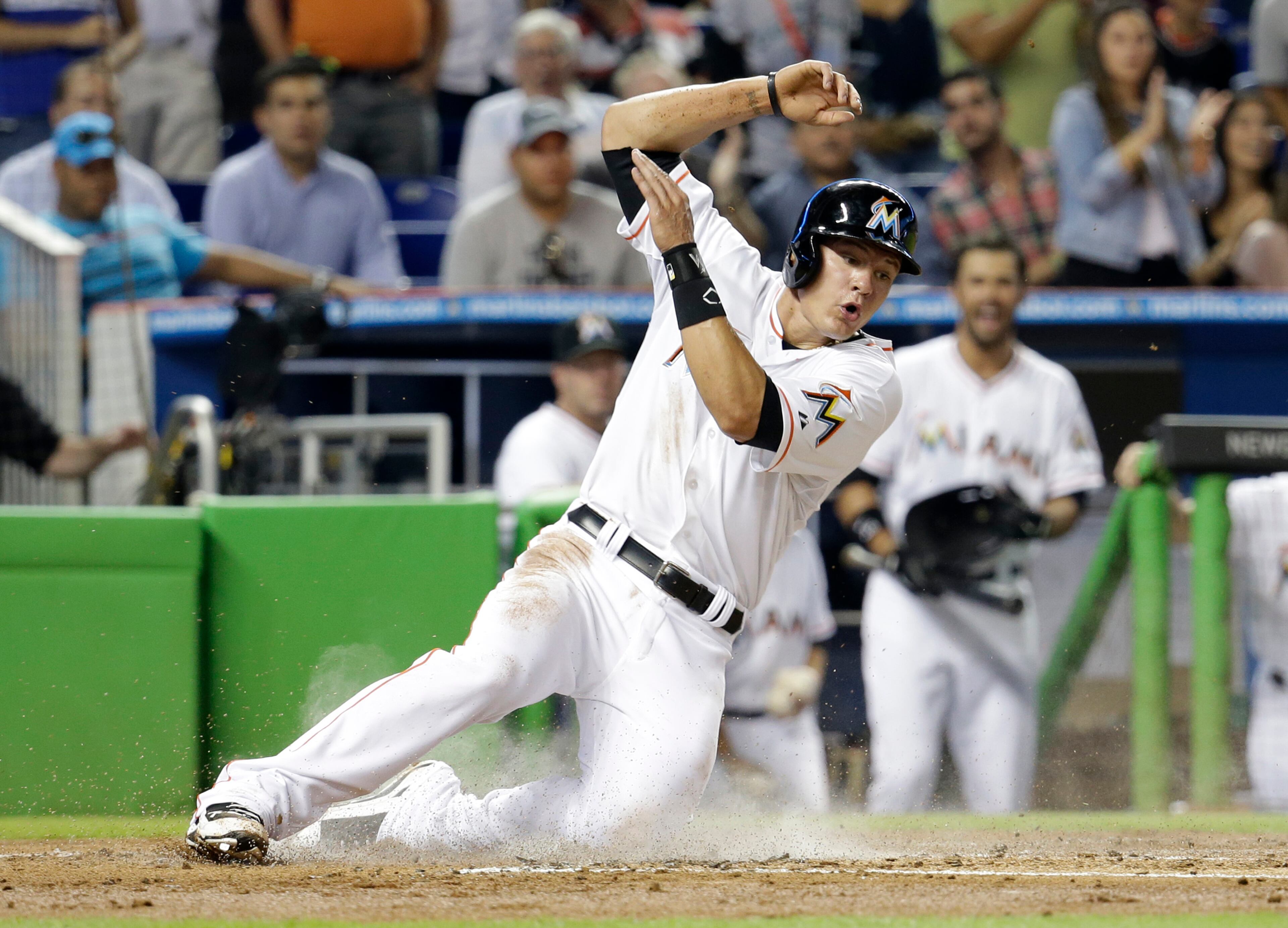Miami Marlins' Derek Dietrich scores on a double hit by Casey McGehee in the first inning of a baseball game against the Atlanta Braves, Thursday, May 1, 2014, in Miami. (AP Photo/Lynne Sladky)
