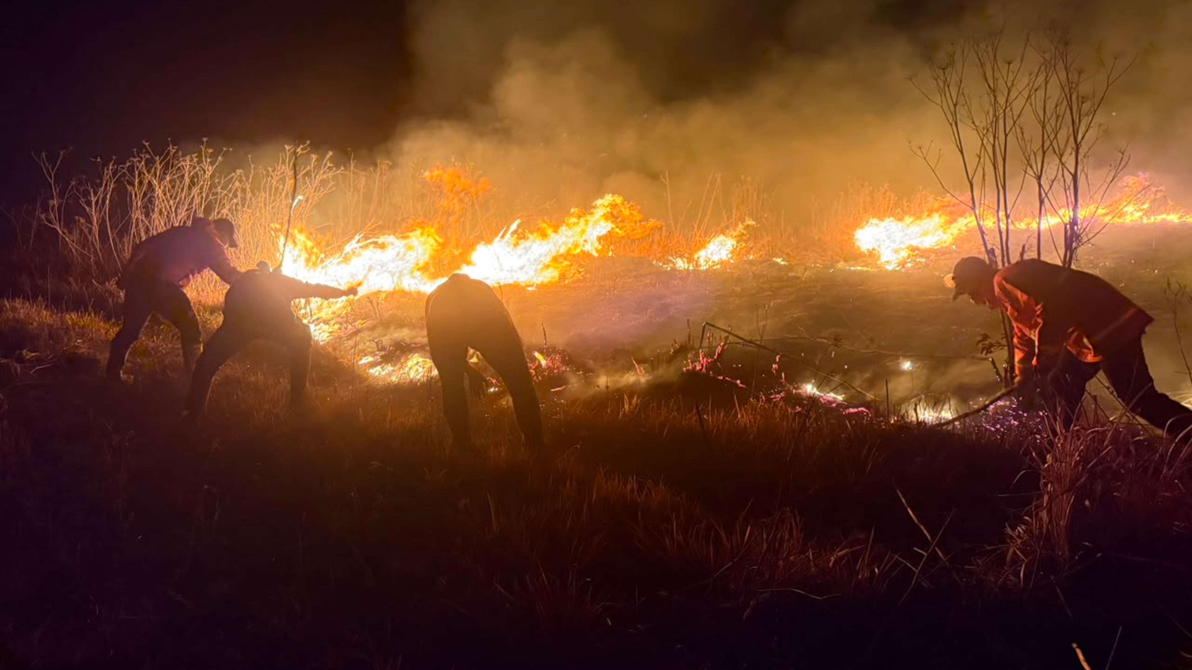 In this photo released by the East Java Regional Disaster Mitigation Agency, firefighters attempt to extinguish a wildfire that razes through Mount Bromo National Park in Probolinggo, Indonesia on Saturday, Aug. 8, 2026. (East Java Regional Disaster Mitigation Agency via AP)