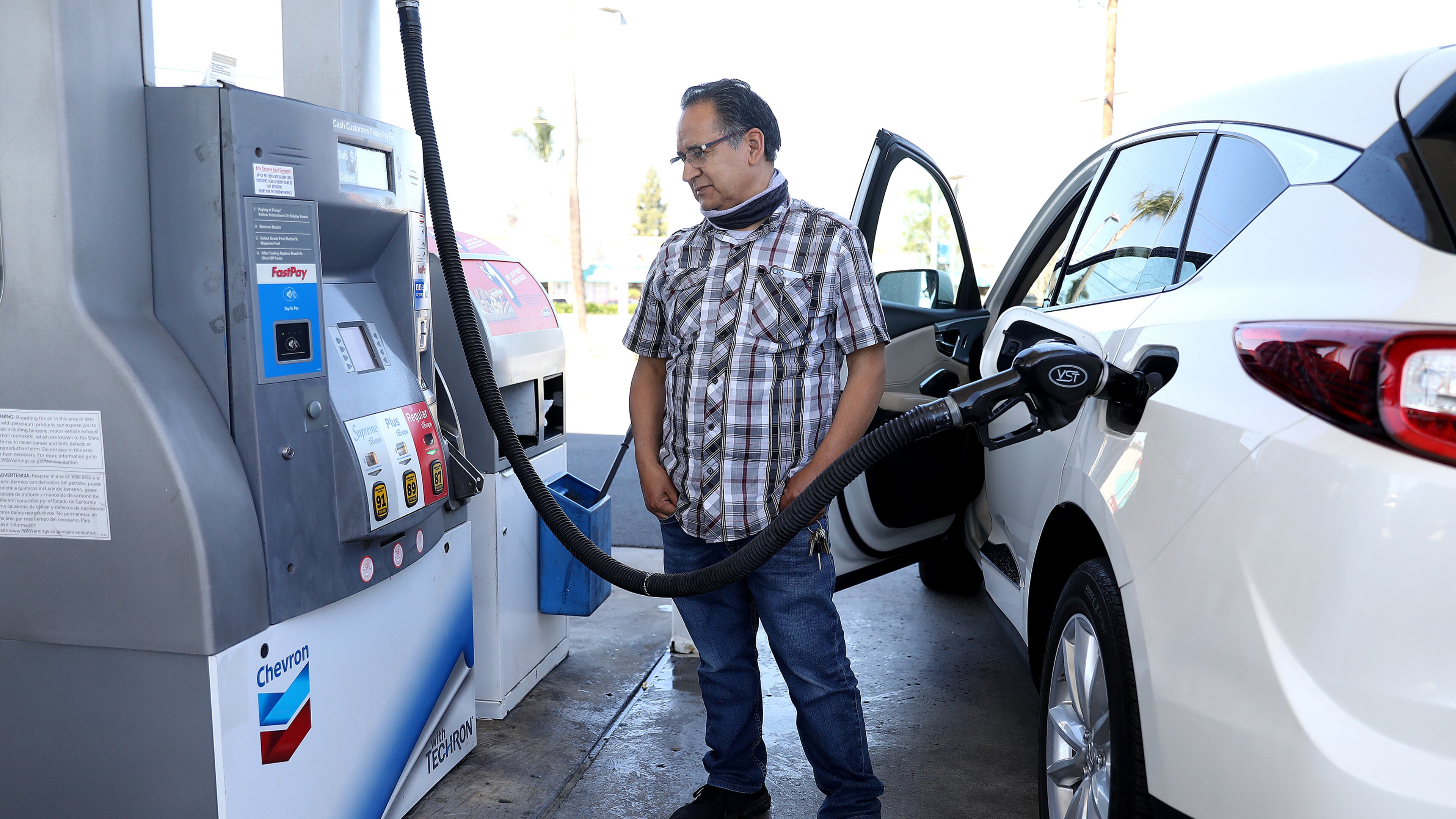 Juan Galaiviz of Santa Ana, California, pumps gas into his automobile at a Chevron gas station on March 8, 2022. Galaiviz paid $50.00 for 8.866 gallons of regular gasoline. (Gary Coronado/Los Angeles Times/TNS)