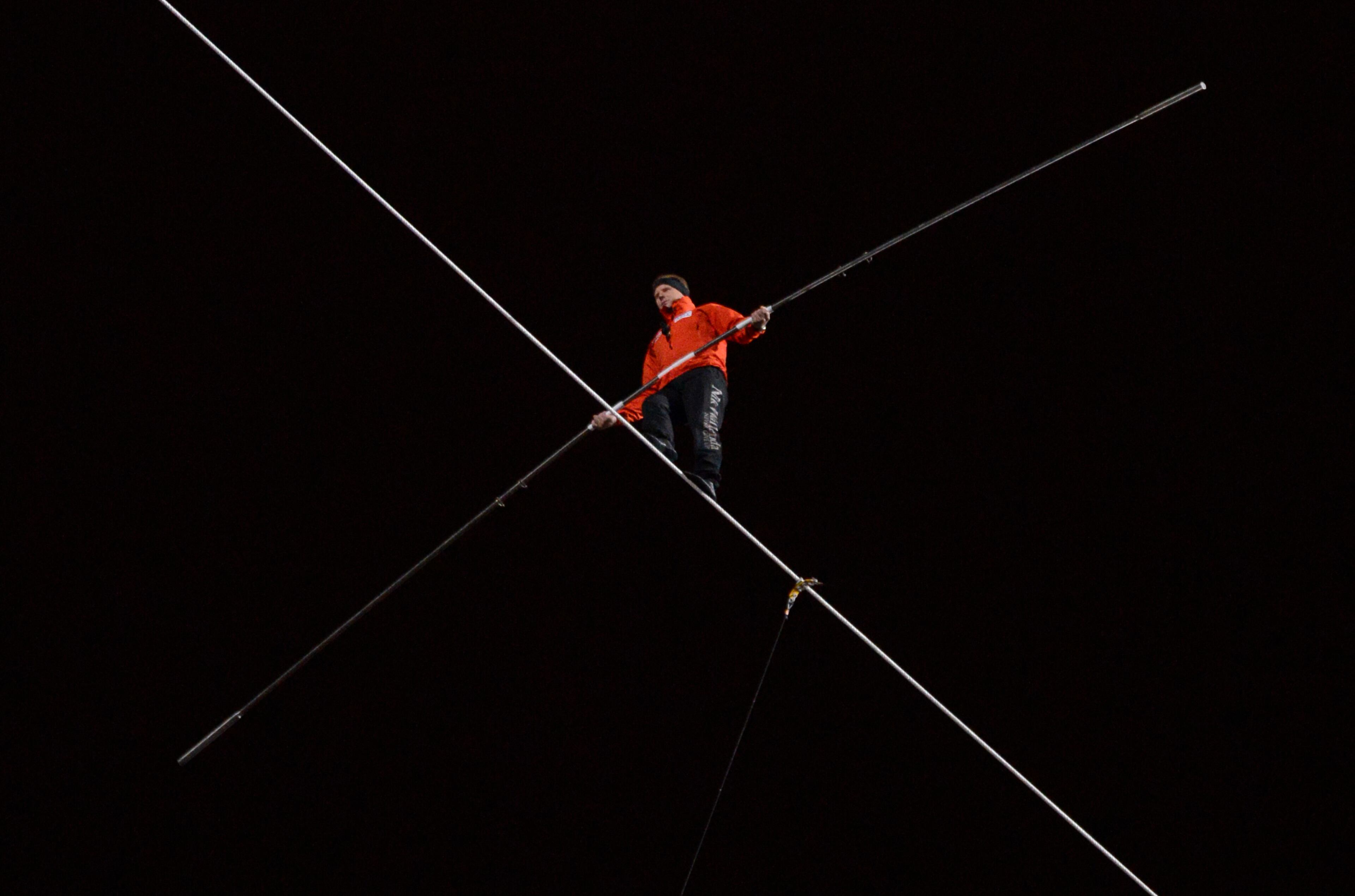 In this Nov. 2, 2014 file photo, daredevil Nik Wallenda walks on a tightrope uphill from the Marina City west tower across the Chicago River to the top of the Leo Burnett Building in Chicago. On Wednesday April 29, 2015, Wallenda will walk _ untethered _ atop the Orlando Eye, a 400-foot high Ferris wheel in Orlando, Fla., as it spins. (AP Photo/Paul Beaty, File)