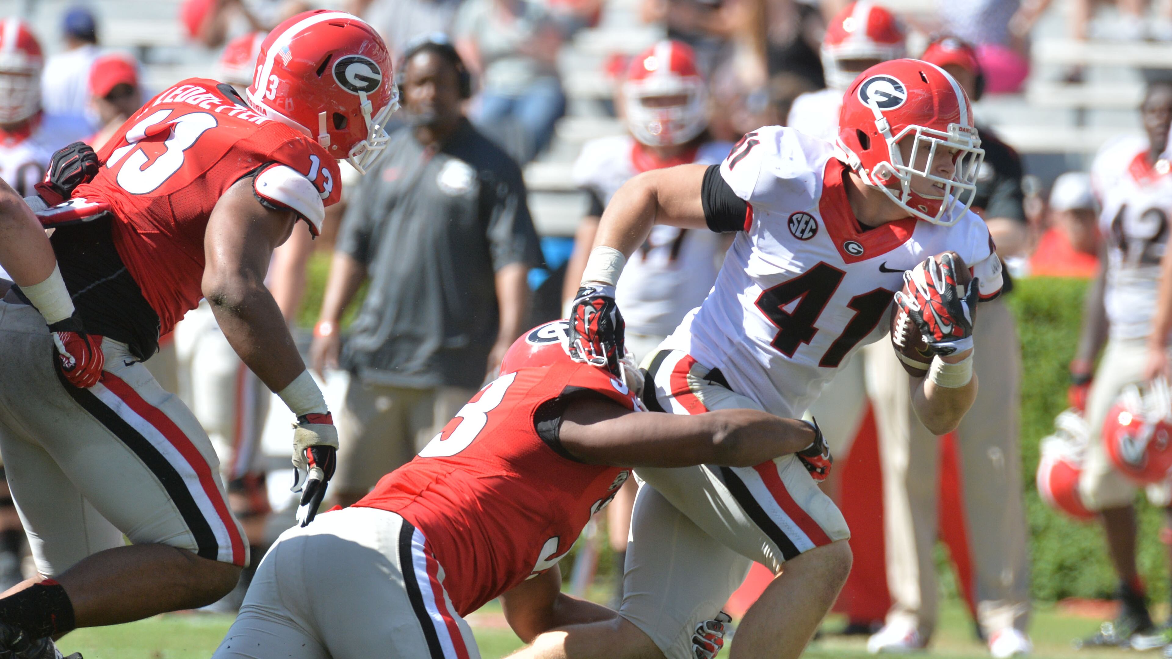 Georgia fullback Christian Payne (41) is tackled by Detric Bing-Dukes (33) in the G-Day game at Sanford Stadium in April. Supporting Bing-Dukes is early-enrollee freshman Jonathan Ledbetter (13). HYOSUB SHIN / HSHIN@AJC.COM