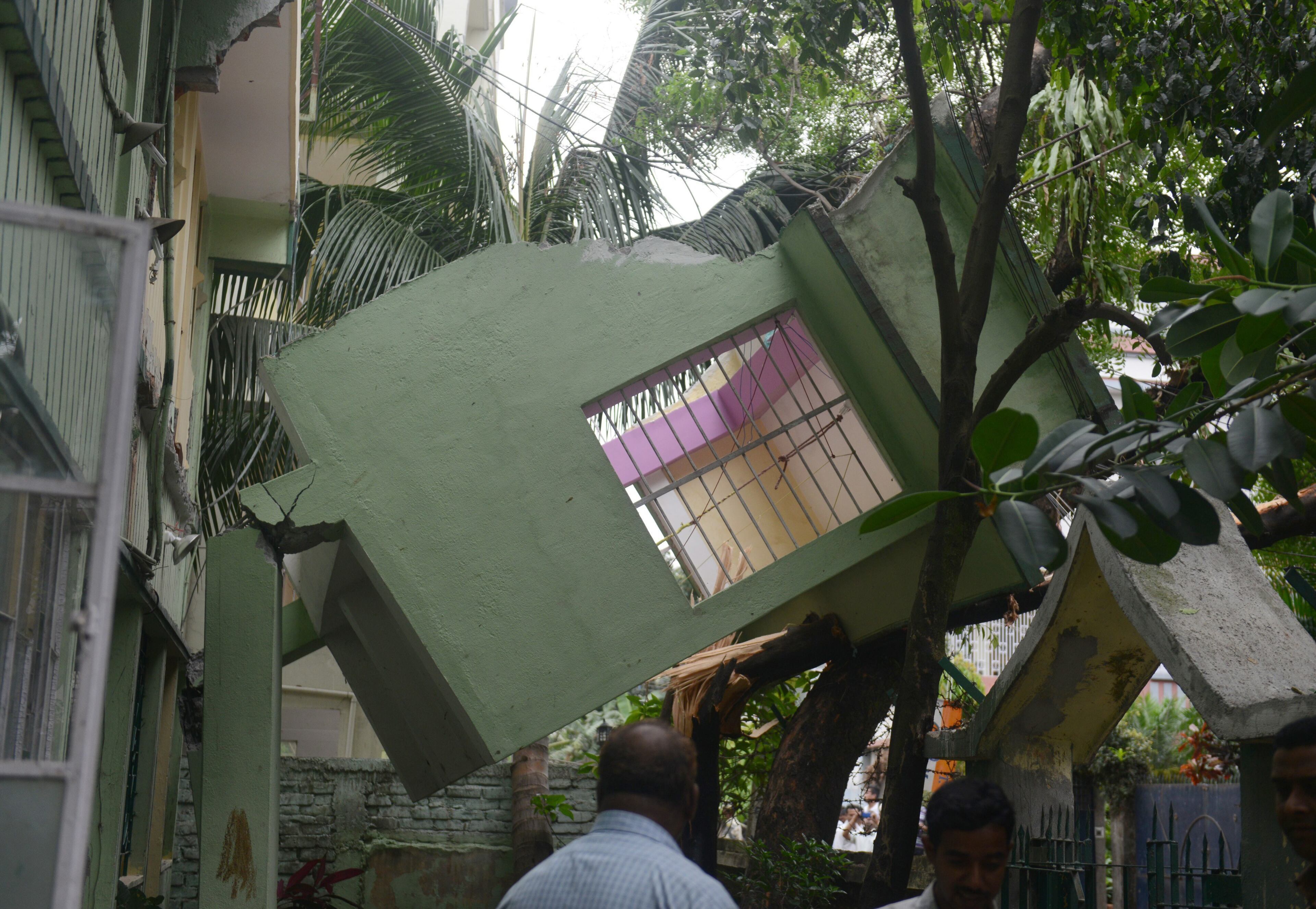 Indian bystanders look at a collapsed house following an earthquake, in Siliguri on April 25, 2015. A powerful 7.9 magnitude earthquake struck Nepal, causing massive damage in the capital Kathmandu with strong tremors felt across neighbouring countries. Witnesses and media reports said the quake tremors lasted between 30 seconds and two minutes and were felt across the across the border in India, including in the capital New Delhi. AFP PHOTO / Diptendu DUTTA (Photo credit should read DIPTENDU DUTTA/AFP/Getty Images)