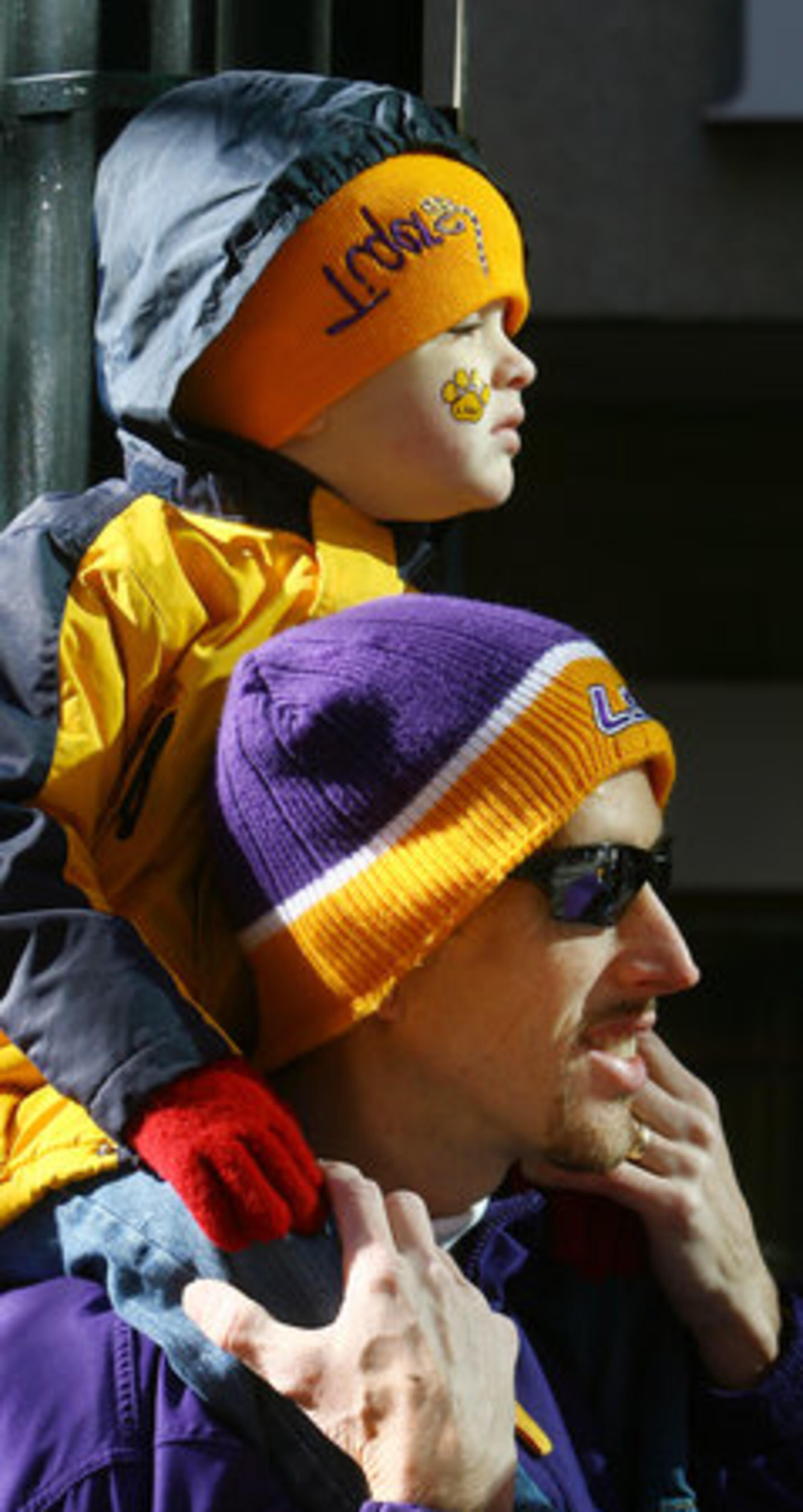 LSU fans Clay Smith and his son, Chandler Smith, 3, of Jonesboro, La., watch the parade.