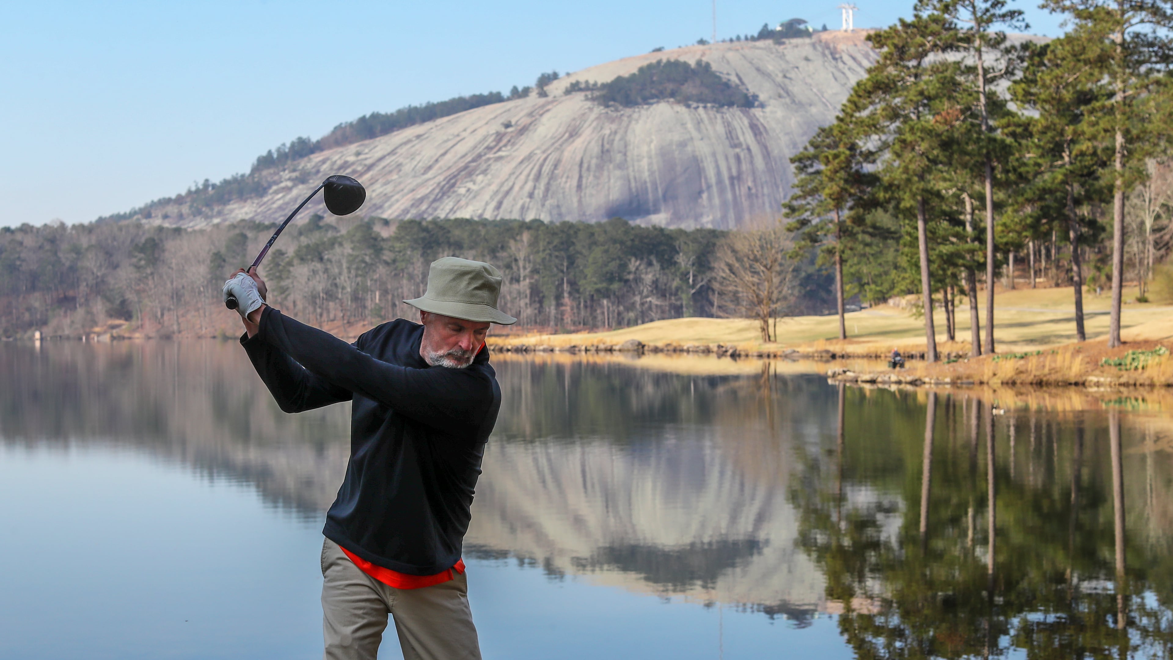 Steve Buckner gets ready to tee off near Stone Mountain Lake in Stone Mountain Park where he and a friend took in a morning of golf on Friday, March 12, 2021.(John Spink / John.Spink@ajc.com)